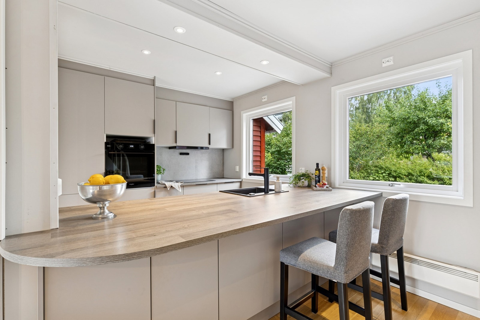 Moderne og stilren HTH kjøkkeninnredning fra 2024 med glatte fronter i tidsriktig farge. Kjøkkenet ligger i åpen og sosial løsning mot stuen Galleribilde