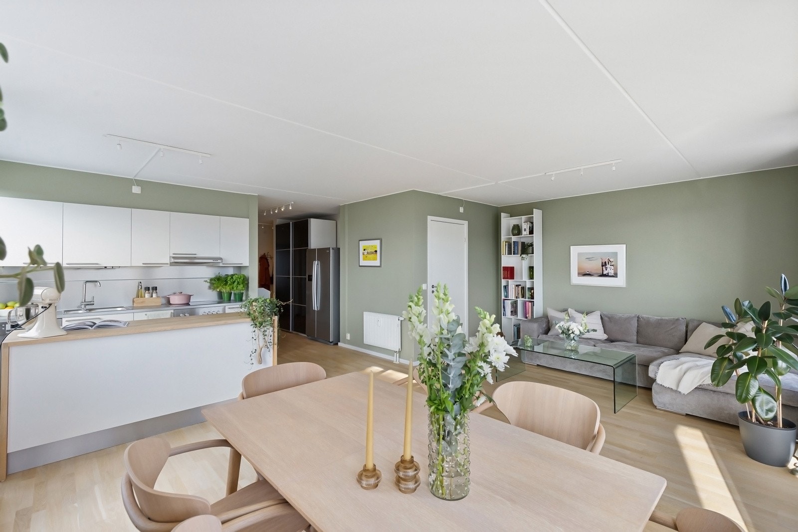 En stor kjøkkenøy fungerer som en naturlig romdeler mellom stue og kjøkken. Galleribilde