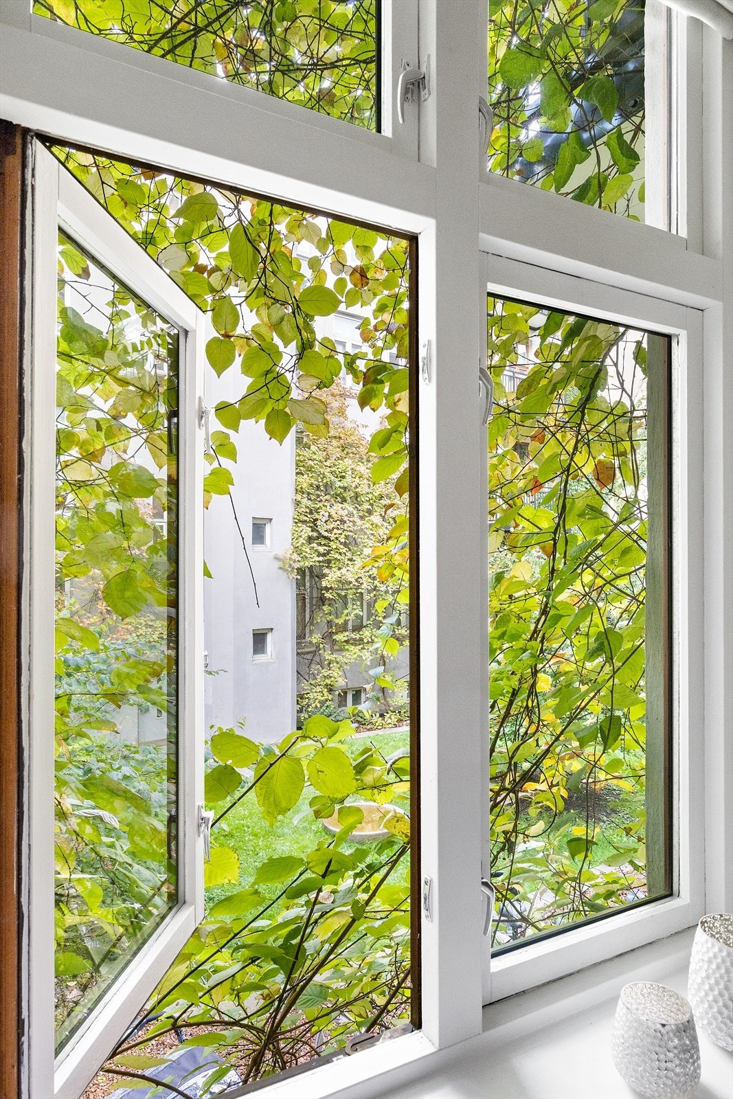 Herlig utsyn ut mot frodig bakgård fra både kjøkken og soverom. Galleribilde