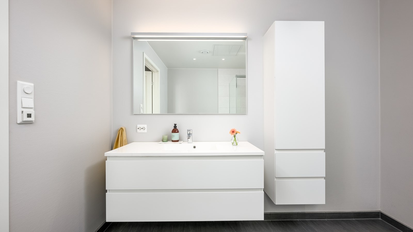 Baderomsinnredningen har hvite fronter og består av en heldekkende servant på en skuffeseksjon Galleribilde