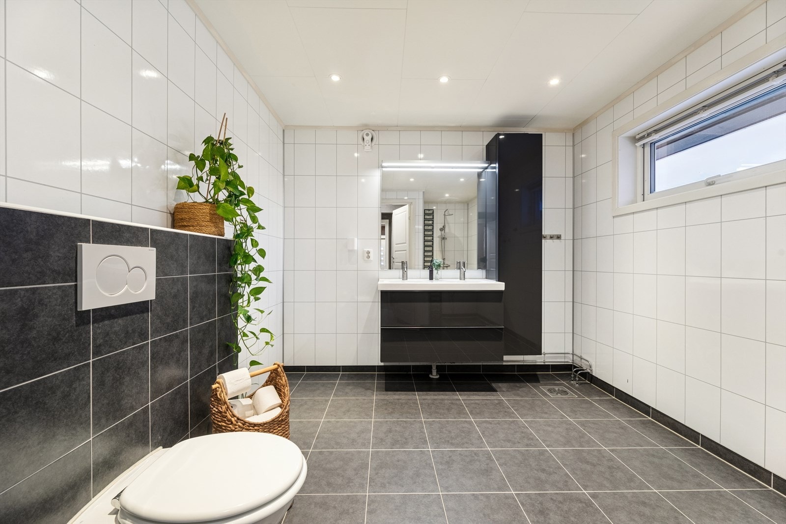 Innredningen består av en praktisk seksjon med to nedfelte servanter og skuffer, samt vegghengt skap for ekstra oppbevaring. Galleribilde