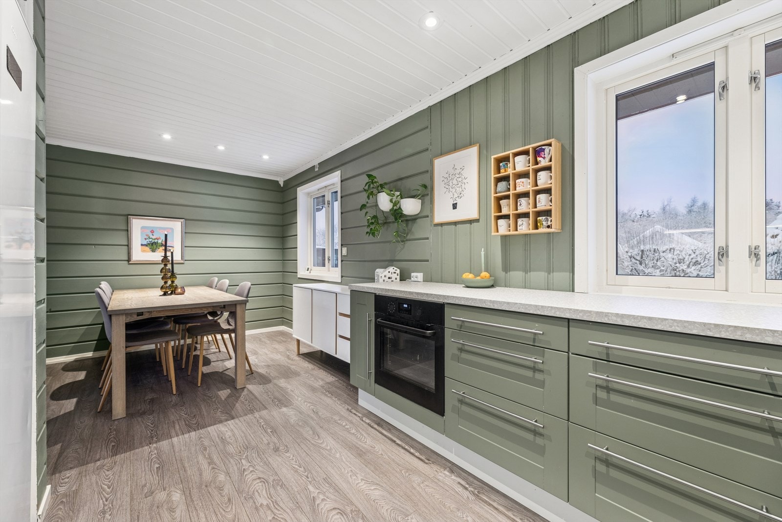 Innredningen har stilrene profilerte fronter i hvitt og grønt, kombinert med en laminatbenkeplate med overlimt servant. Galleribilde