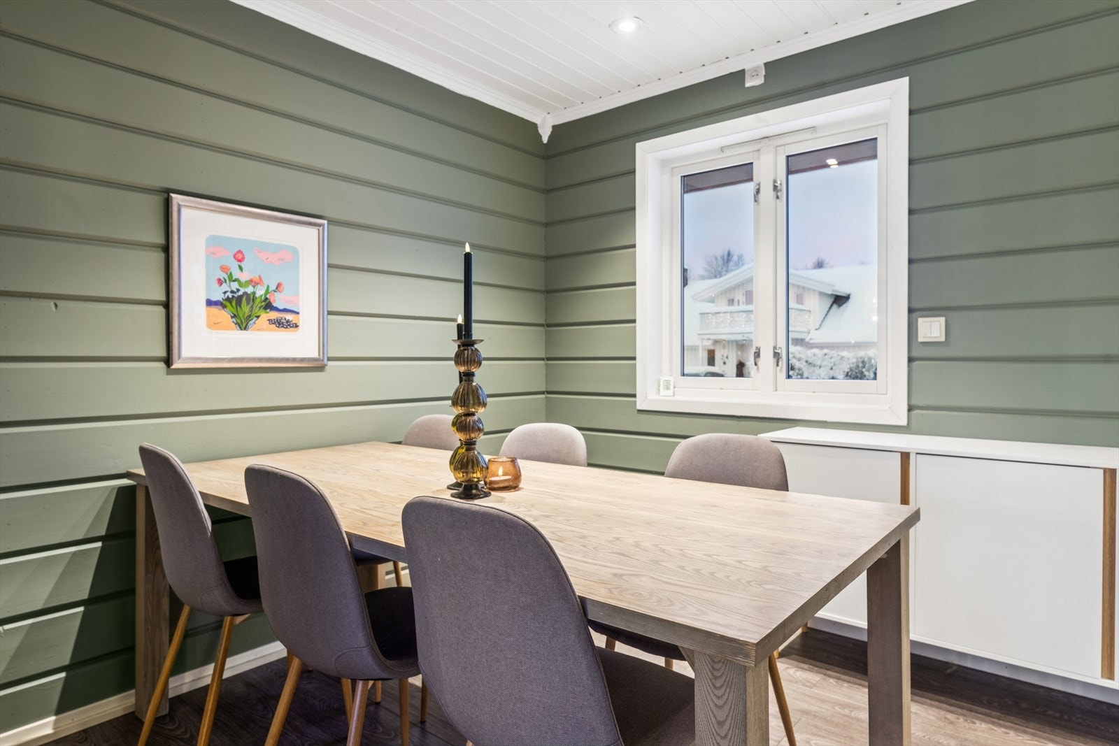 Vegger med trepanel gir en lun og klassisk følelse i spiseområdet. Galleribilde