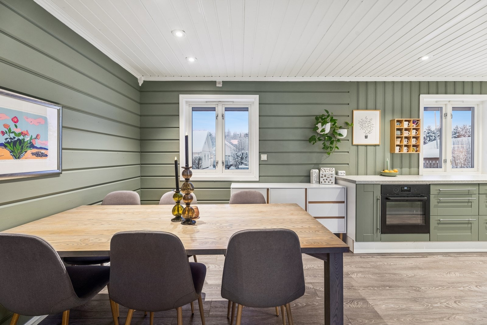 Kjøkkenet har store vinduer som slipper inn rikelig med naturlig lys, og i taket er det montert stilrene downlights som gir en moderne og behagelig belysning. Galleribilde