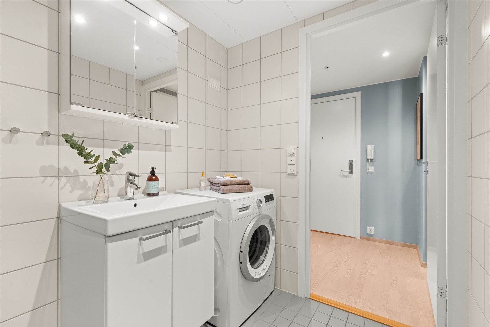 Badet er innredet med vegghengt klosett, servant nedfelt i innredning, speilskap og dusjhjørne med svingbare glassdører. Det er både plass og opplegg for vaskemaskin og tørketrommel. Rommet har balansert ventilasjon som sørger for godt inneklima. Galleribilde