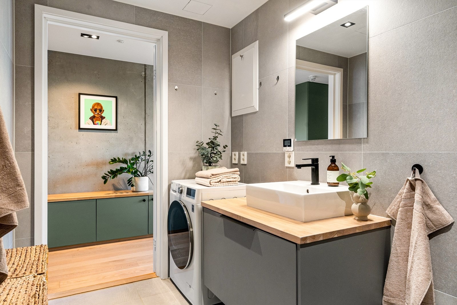 Rommet er utstyrt med dusjhjørne med innfellbare dusjdører, hånd- og regndusjarmatur fra Tapwell, veggmontert toalett og baderomsinnredning fra Poggenpohl med skuff, heltre benkeplate med servant og ettgrepsarmatur fra Tapwell og speil. Galleribilde