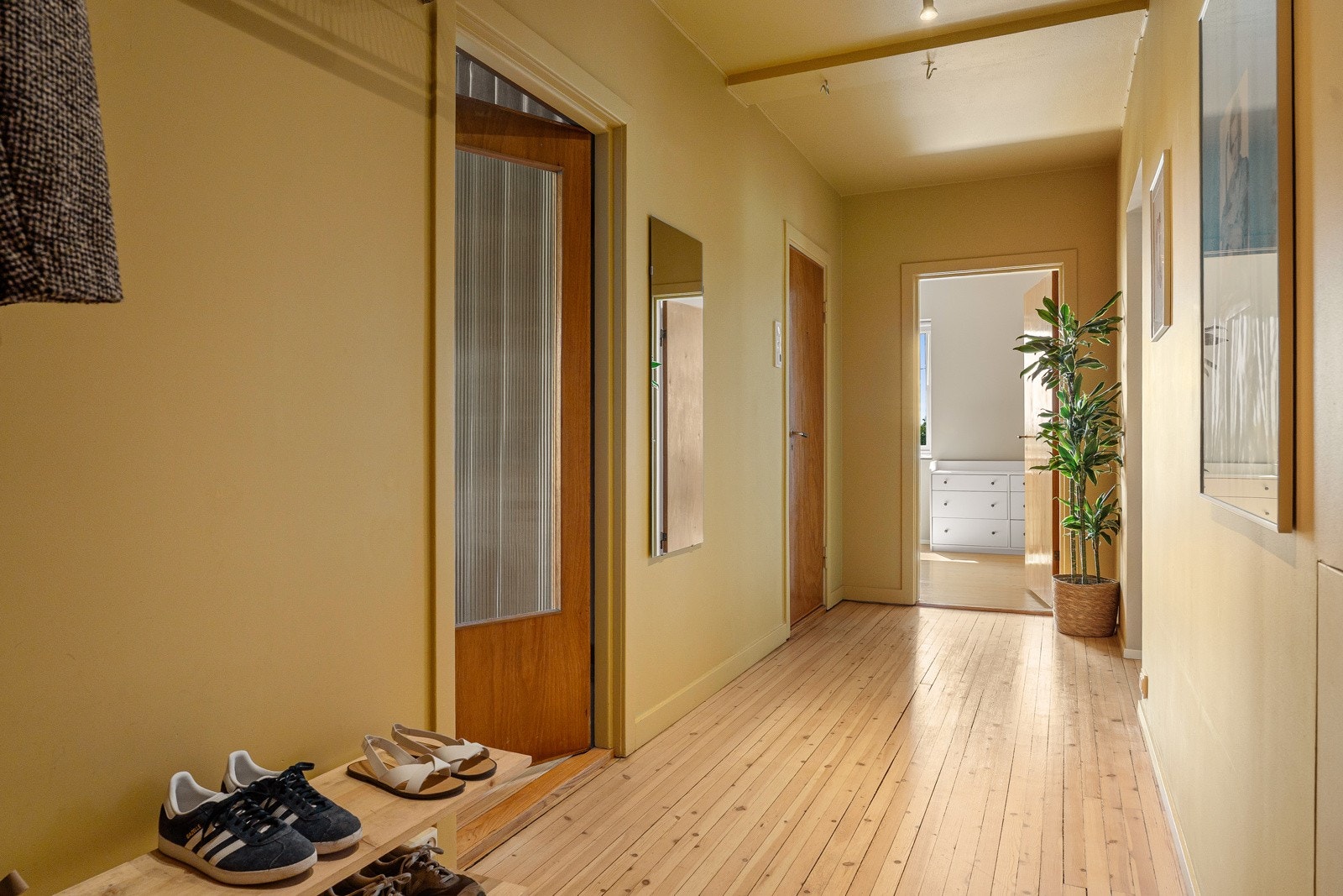 Innbydende entré/gang med veggmonterte hyller som gir praktisk oppbevaringsplass for yttertøy og sko. Galleribilde