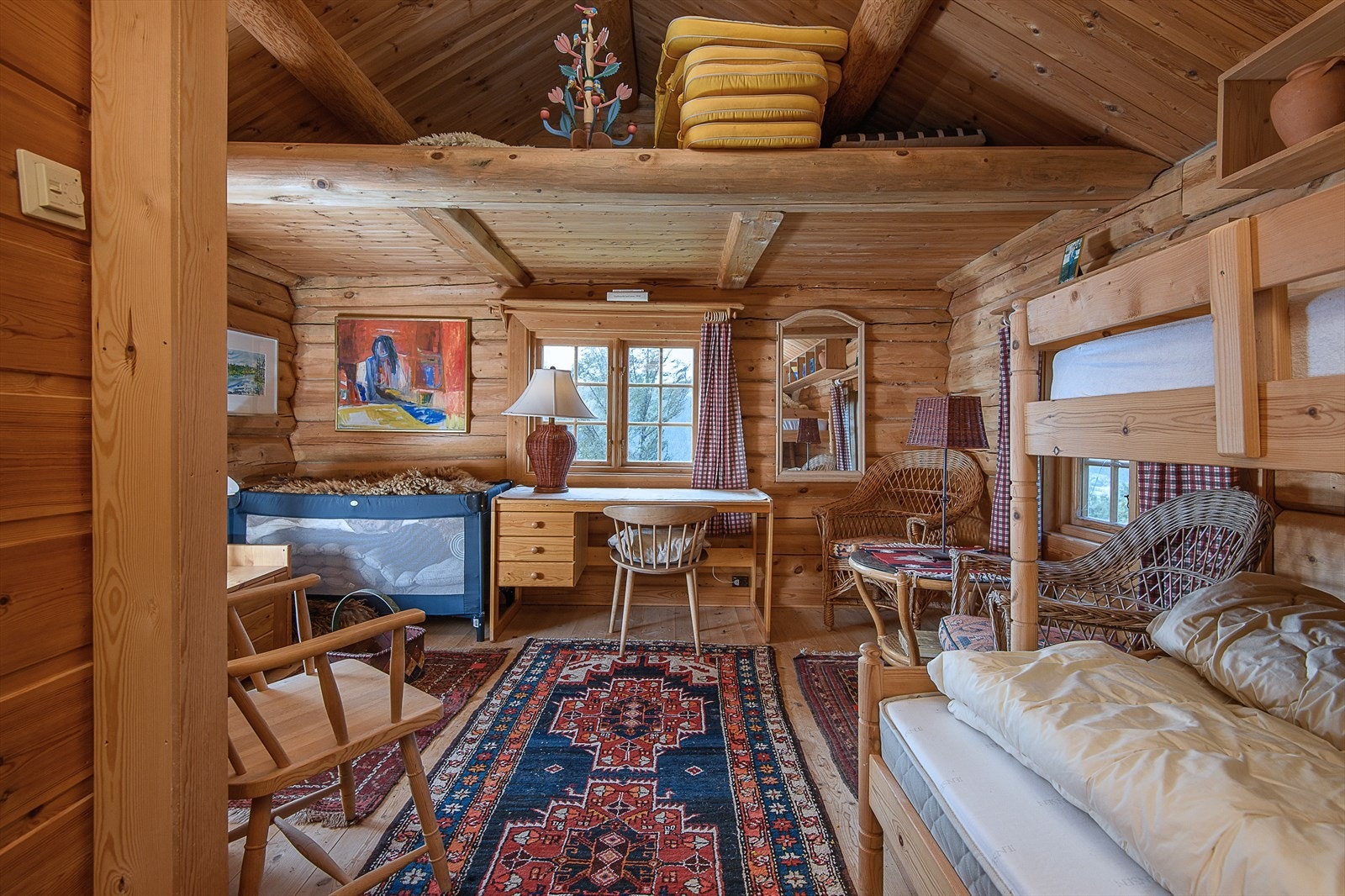 Stuen har en lun og innbydende atmosfære, med plass til både sittegruppe og soveplass. Galleribilde