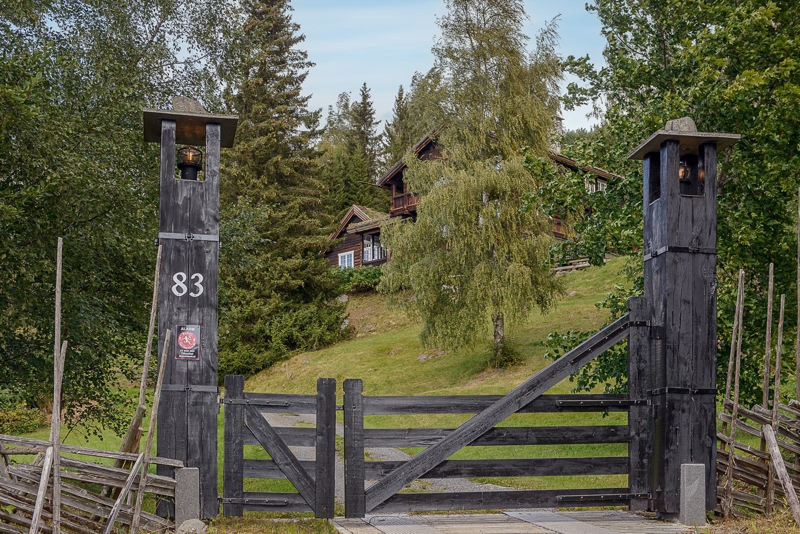 En tradisjonell norsk gårdsport ved åpner veien til en pittoresk eiendom. Galleribilde