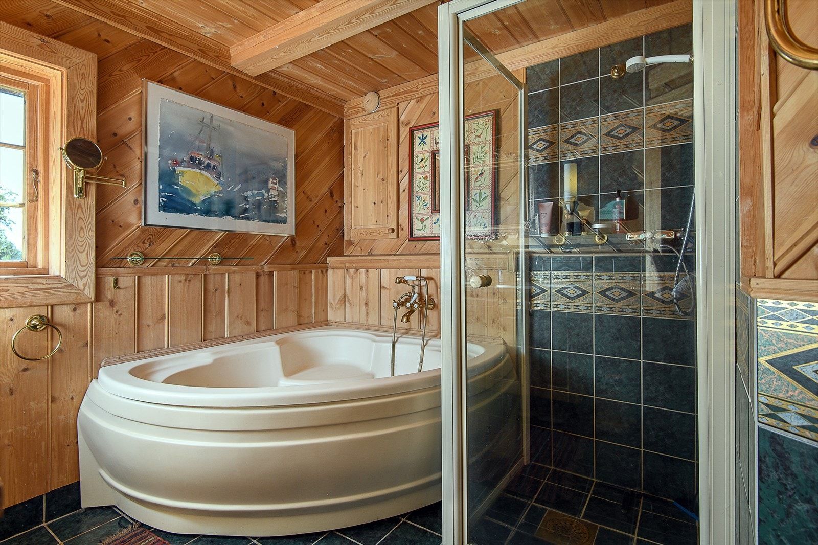 Hovedbadet har en lun og klassisk stil med en kombinasjon av trepanel og delvis flislagte vegger, samt flislagt gulv med behagelige varmekabler Galleribilde