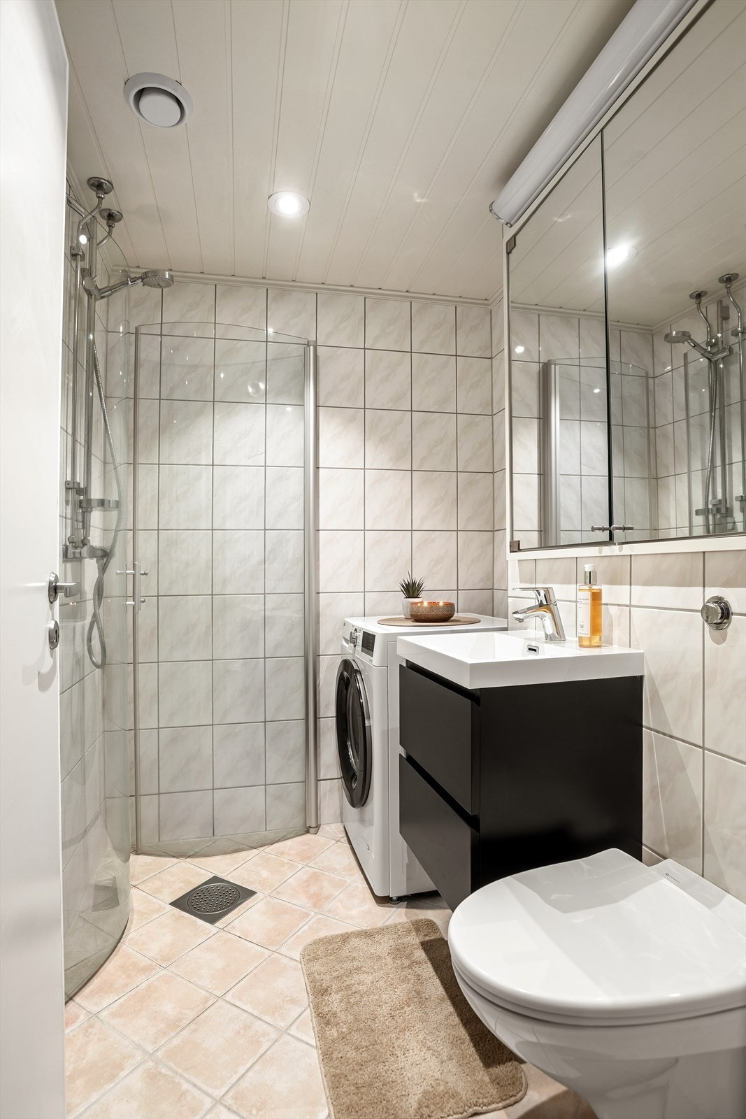 Badet er utstyrt med servant med underskap, dusjnisje med innfellbare dører, speilskap og toalett Galleribilde