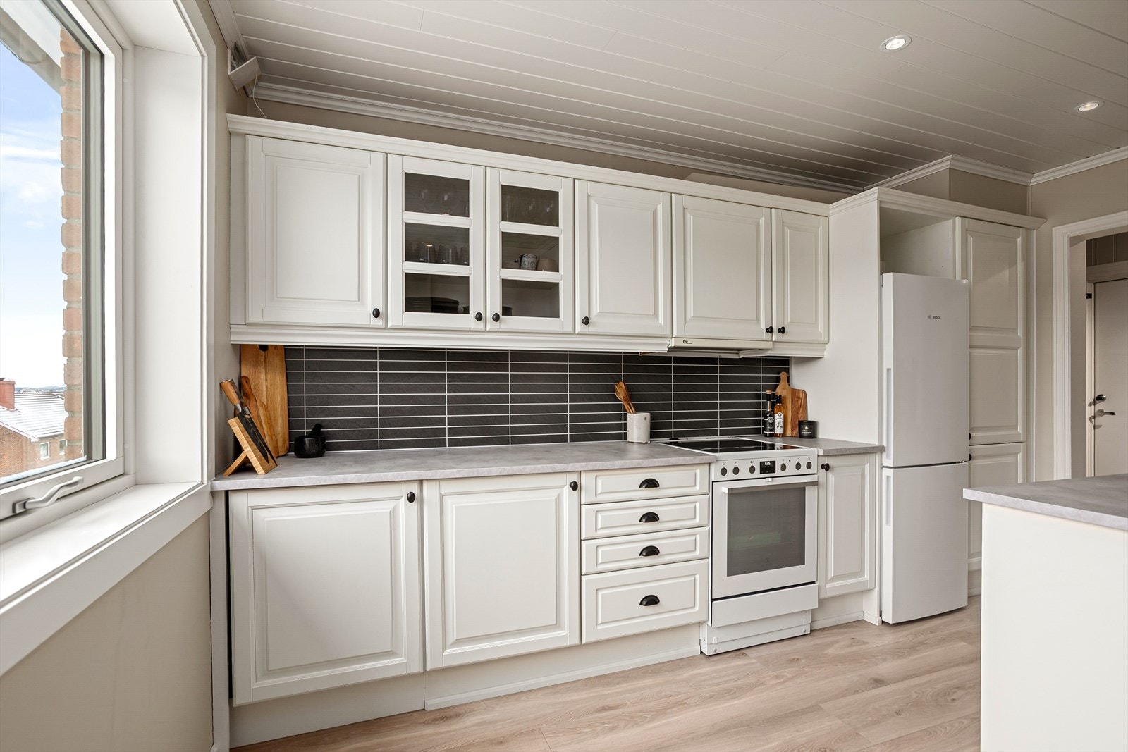 Kjøkkenet er utstyrt med frittstående hvitevarer som komfyr/platetopp, oppvaskmaskin og kjøl/fryseskap Galleribilde