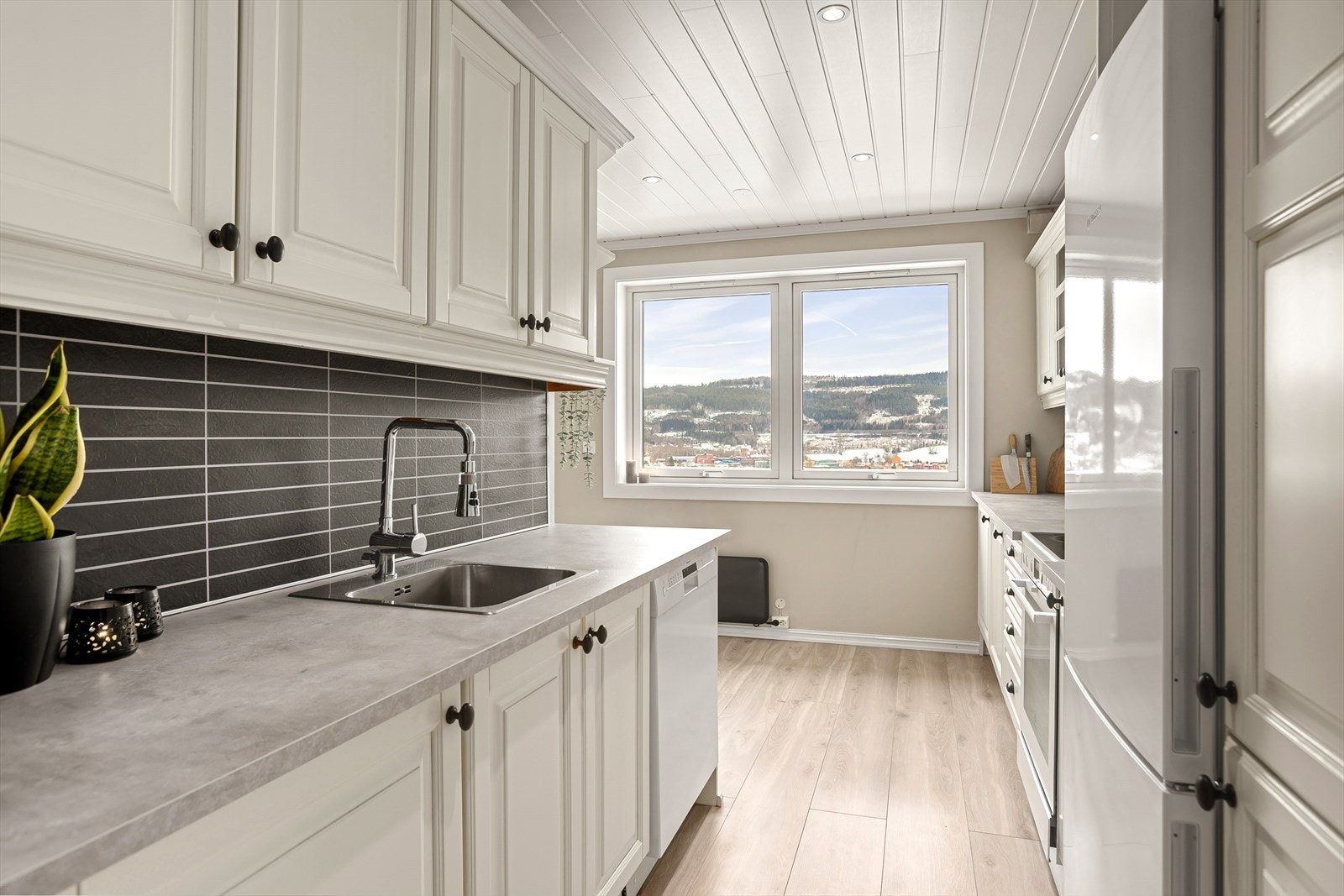 Pent og romslig kjøkken med profilerte fronter og laminert benkeplate med nedfelt vask Galleribilde