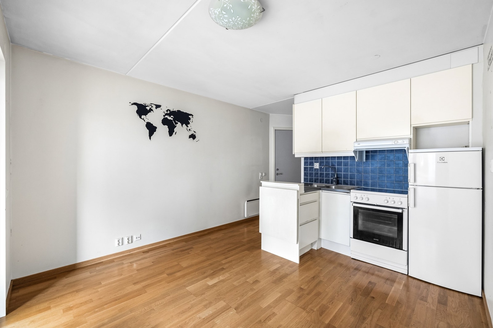 Det er fliser mellom over- og underskap, samt ventilator over kokeplassen. Galleribilde