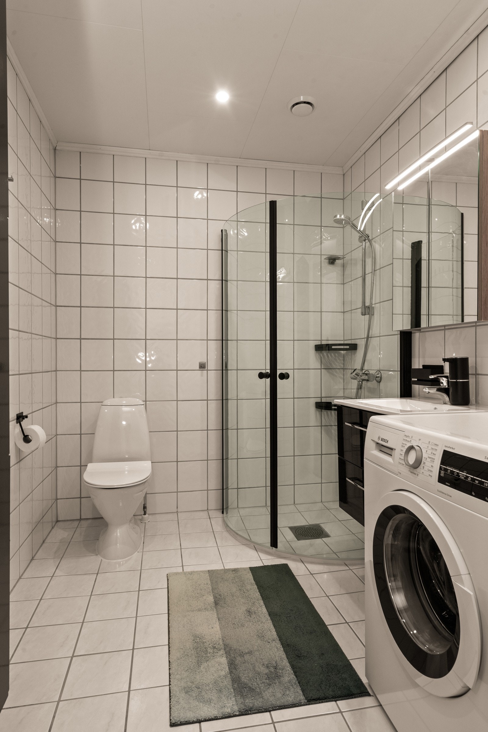 Rommet har nyere innredning, speil og garnityr samt opplegg til vaskemaskin og tørketrommel. Galleribilde