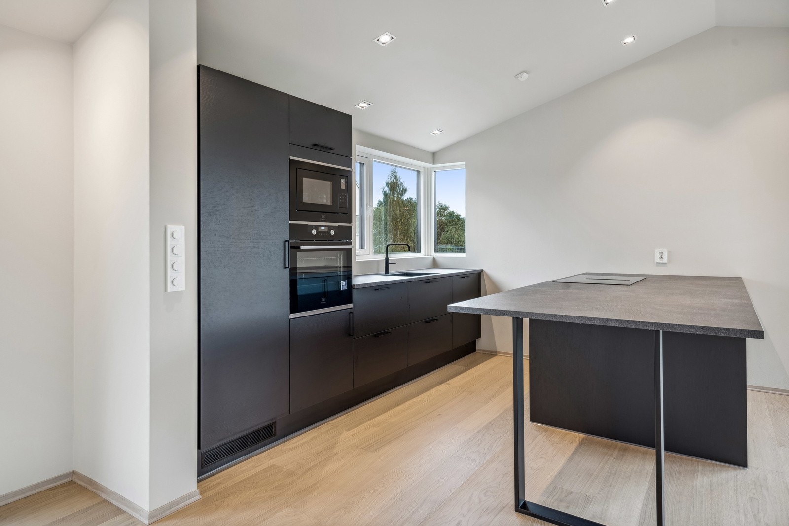 Kjøkkenøyen sikrer god benkeplass og har blant annet integrert vinskap og platetopp med ventilator. Galleribilde