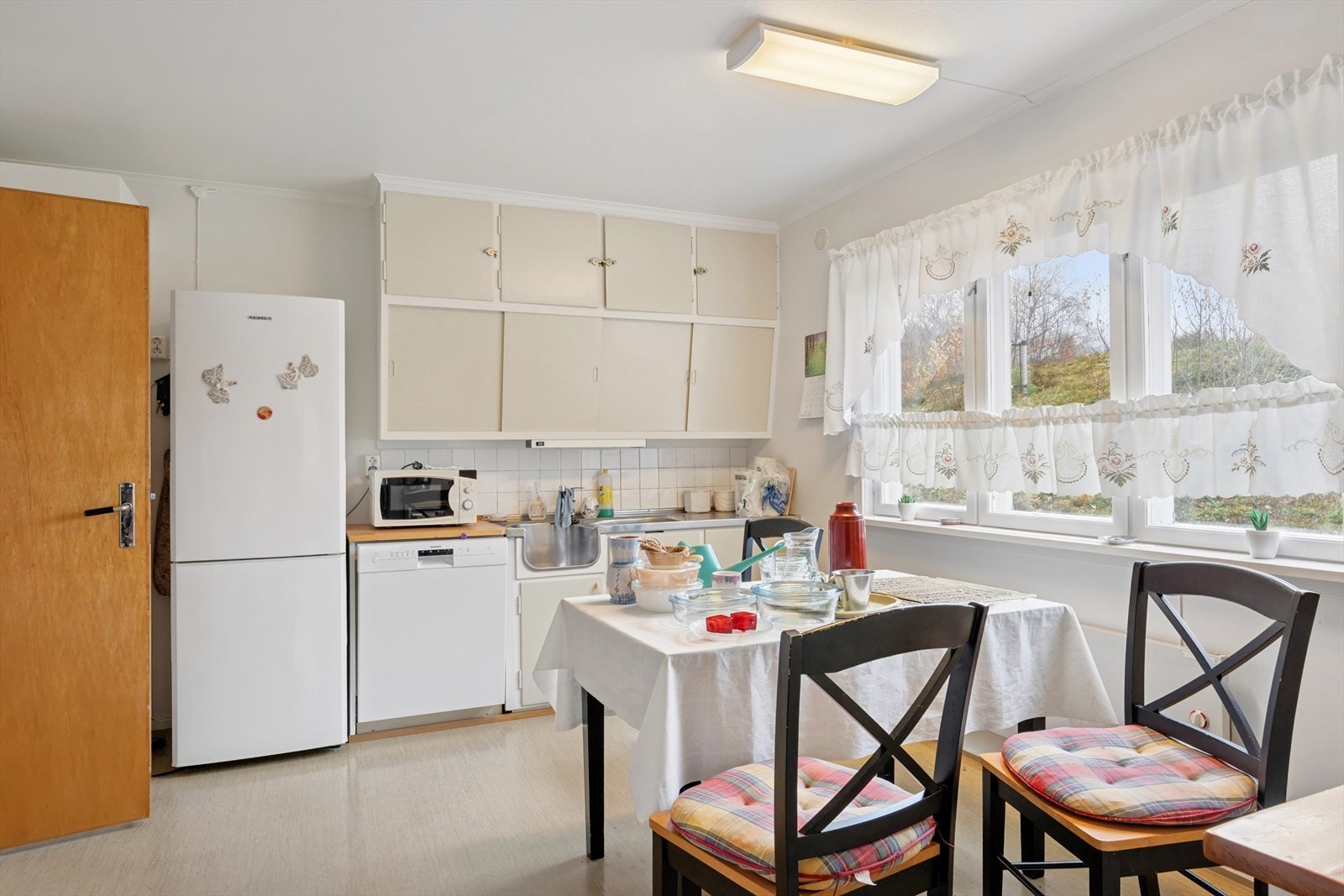 Kjøkkenet har en eldre, delvis plassbygd innredning med malte, glatte fronter og en oppvaskbenk med stålplate, utstyrt med både utslagsvask og vaskekum. Galleribilde