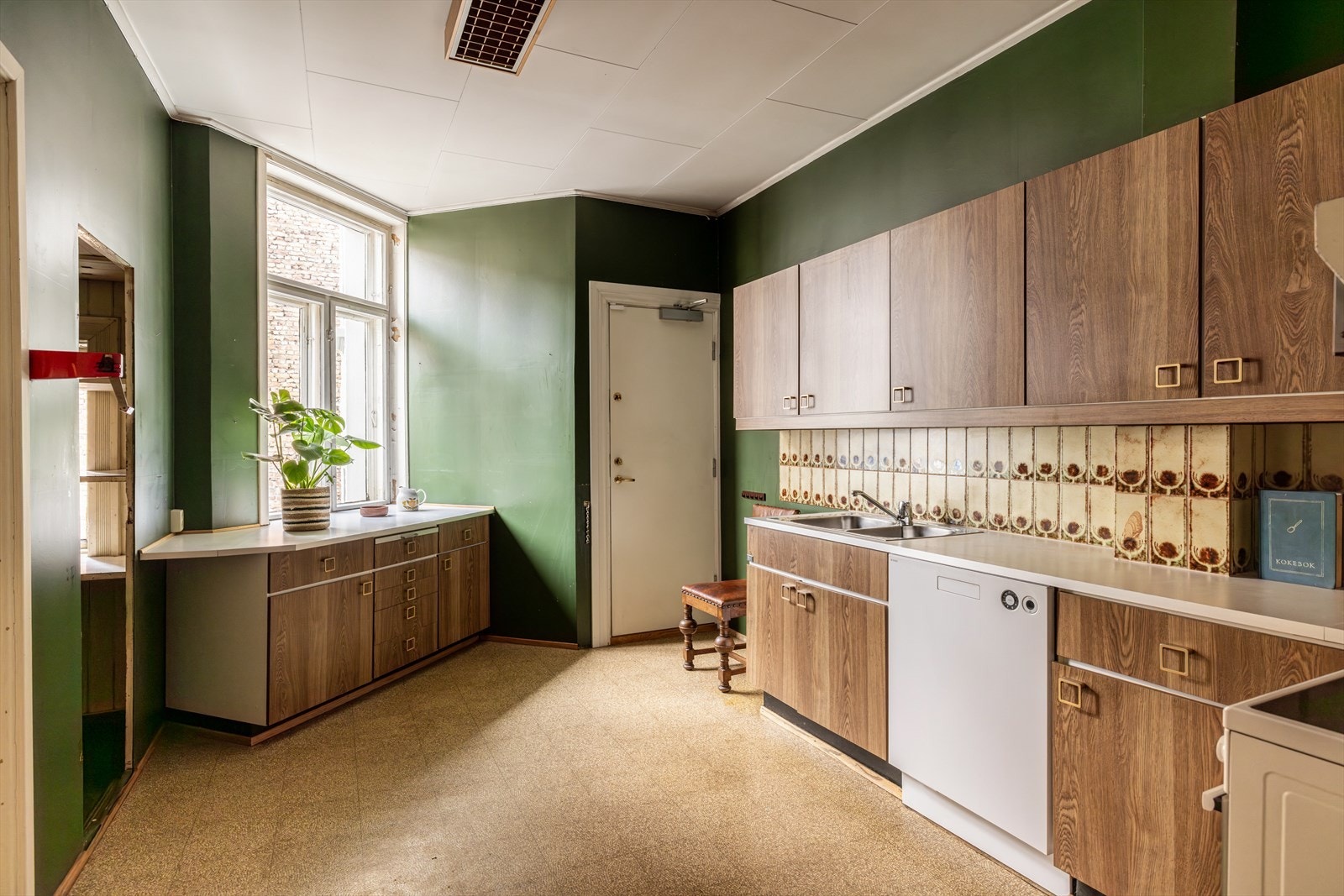 Romslig kjøkken med eldre kjøkkeninnredning og spiskammers. Galleribilde