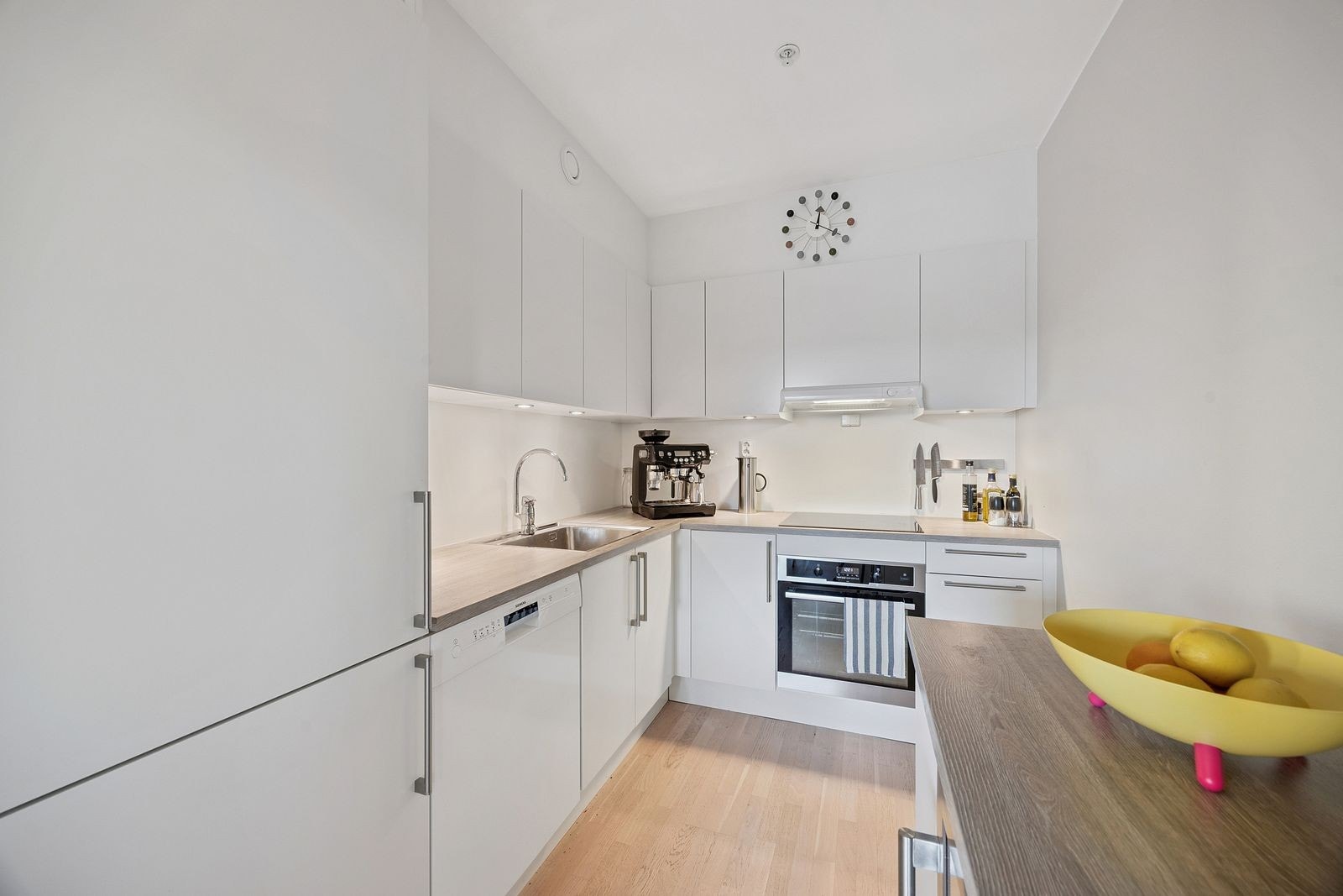 Lekkert kjøkken med integrete hvitevarer samt vinskap Galleribilde