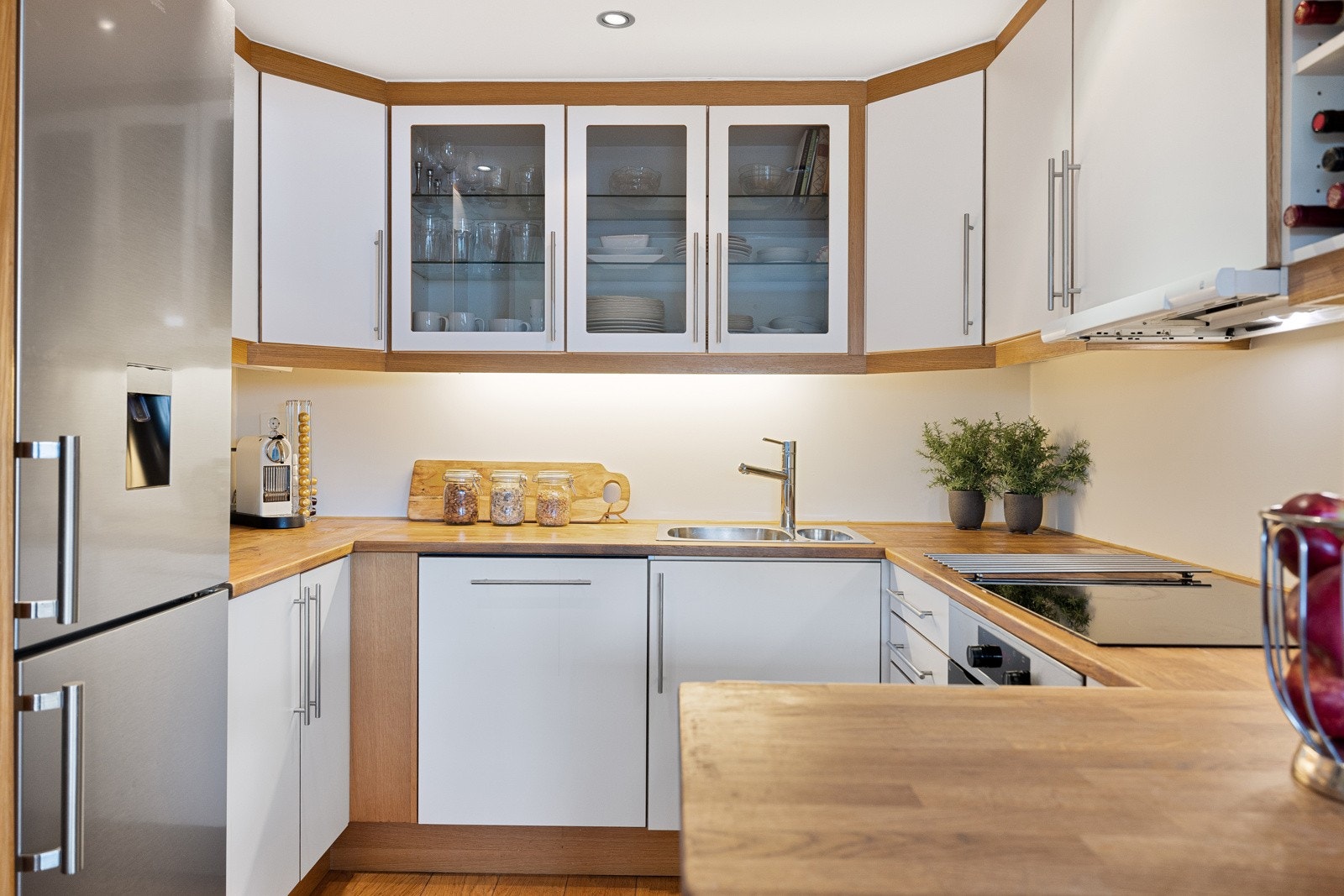 Kjøkkeninnredning fra 2006 med benkeplater av heltre, malt backsplash og slette skapfronter. Galleribilde