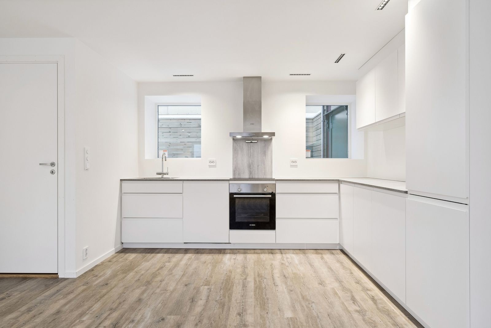 Lekkert kjøkken med integrerte hvitevarer. Kjøkkenet har glatte fronter og benkeplate av laminat. Galleribilde