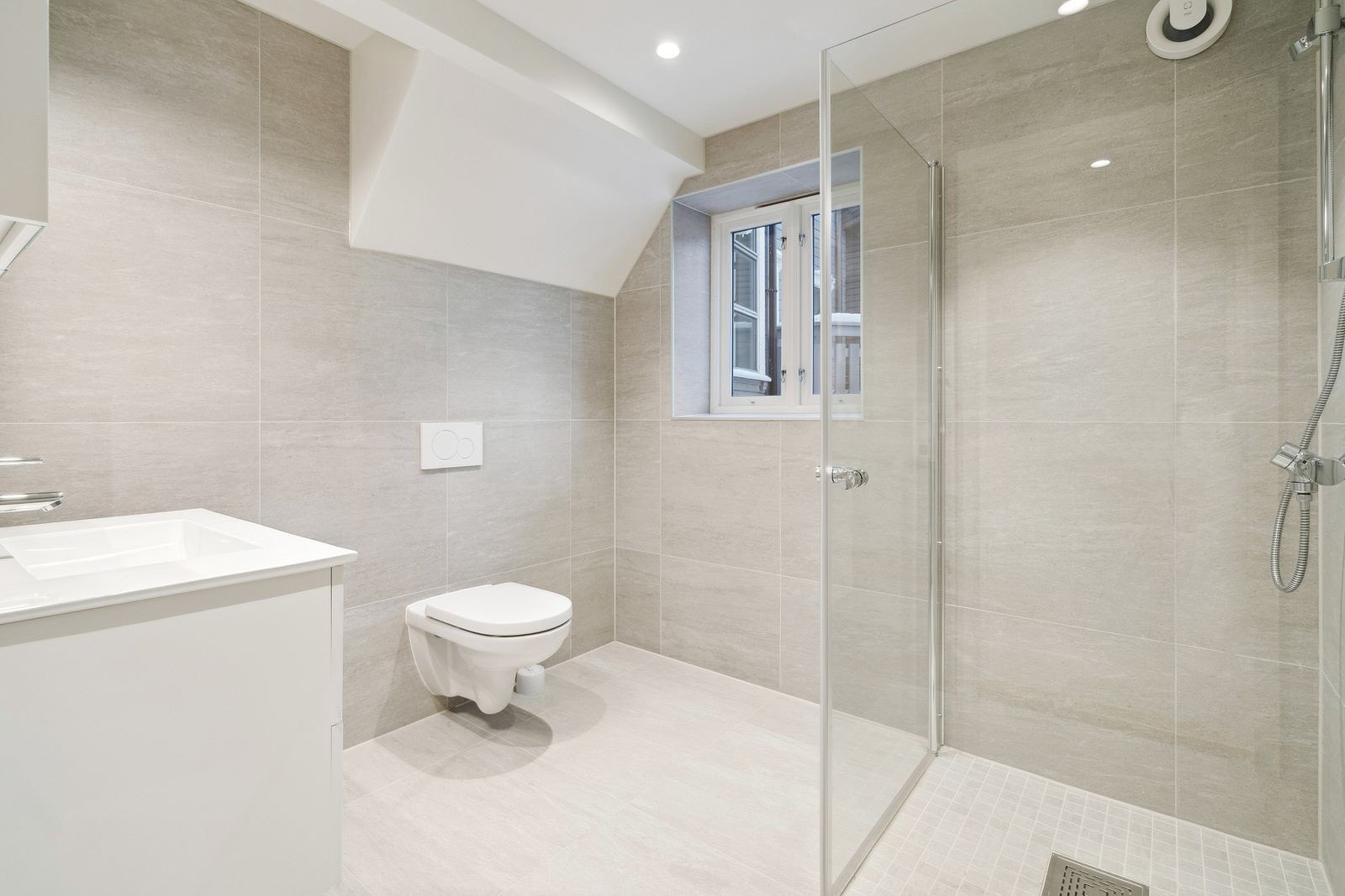 Delikat flislagt baderom med varme i gulv og downlights i himling. Galleribilde