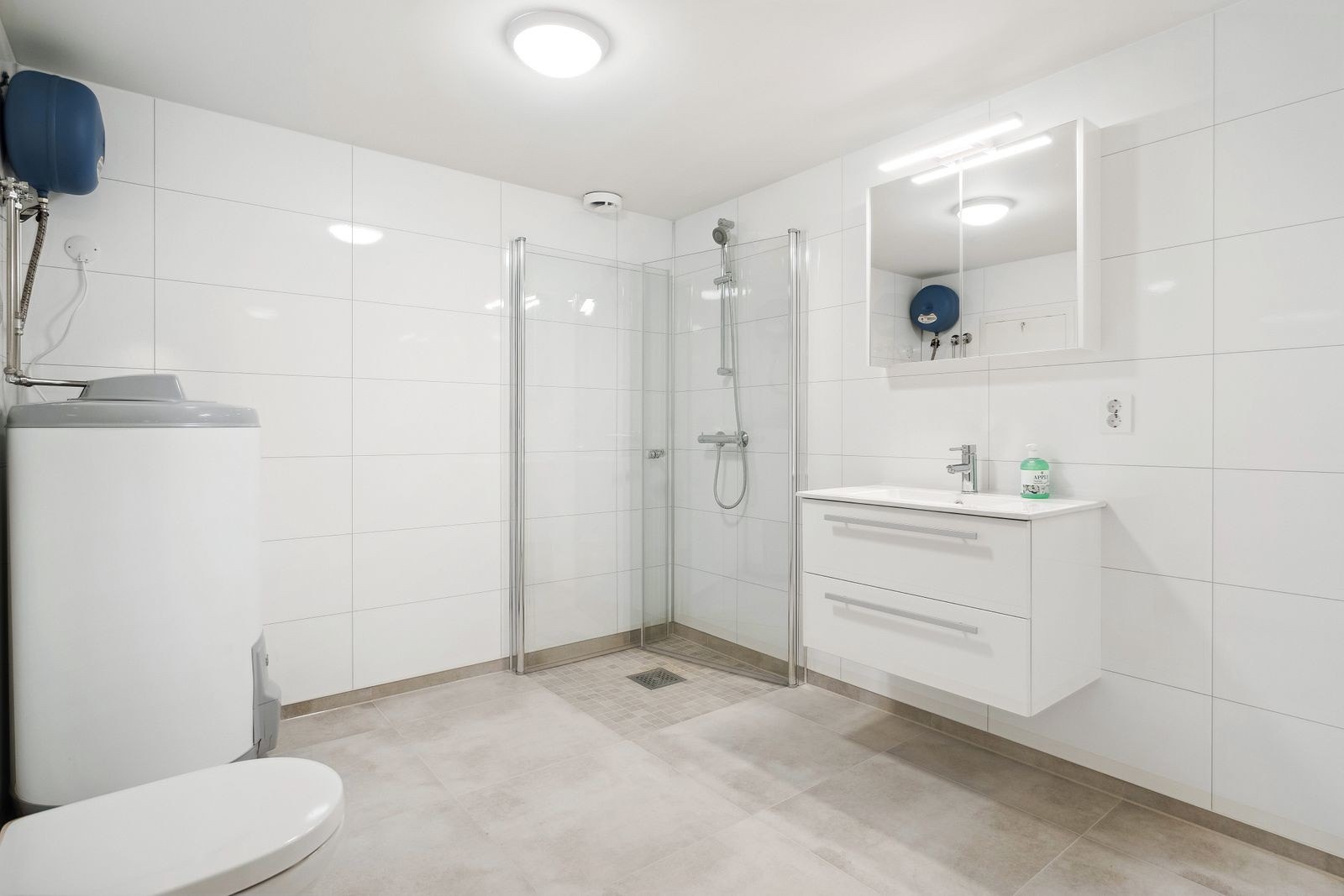 Pent baderom med varmekabler i gulv. Rommet har innredning med nedfelt servant og speilskap. Galleribilde