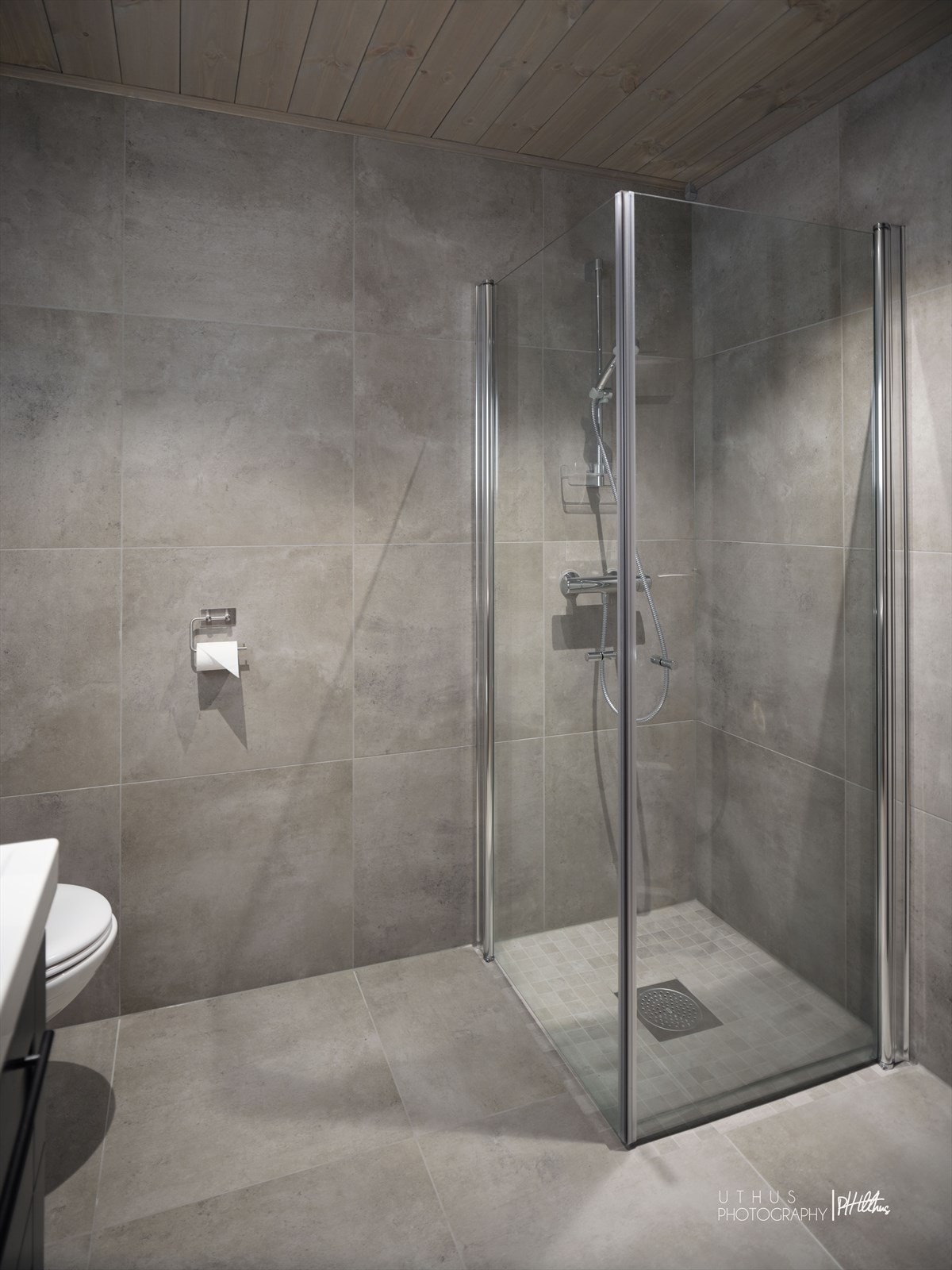 Flislagte overflater og varme i gulv. Innredning med servant, vegghengt toalett og dusjvegger. Galleribilde