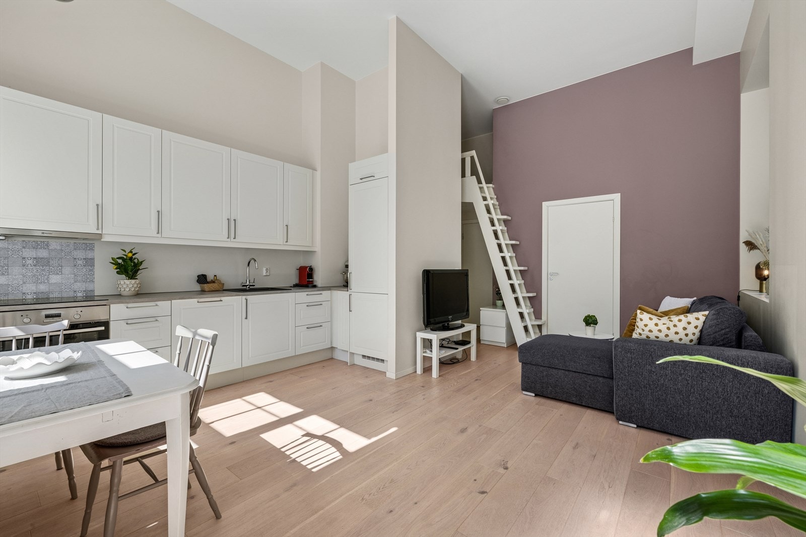 Leilighetens stue er lys med plass til både sofa og tv-møblement Galleribilde