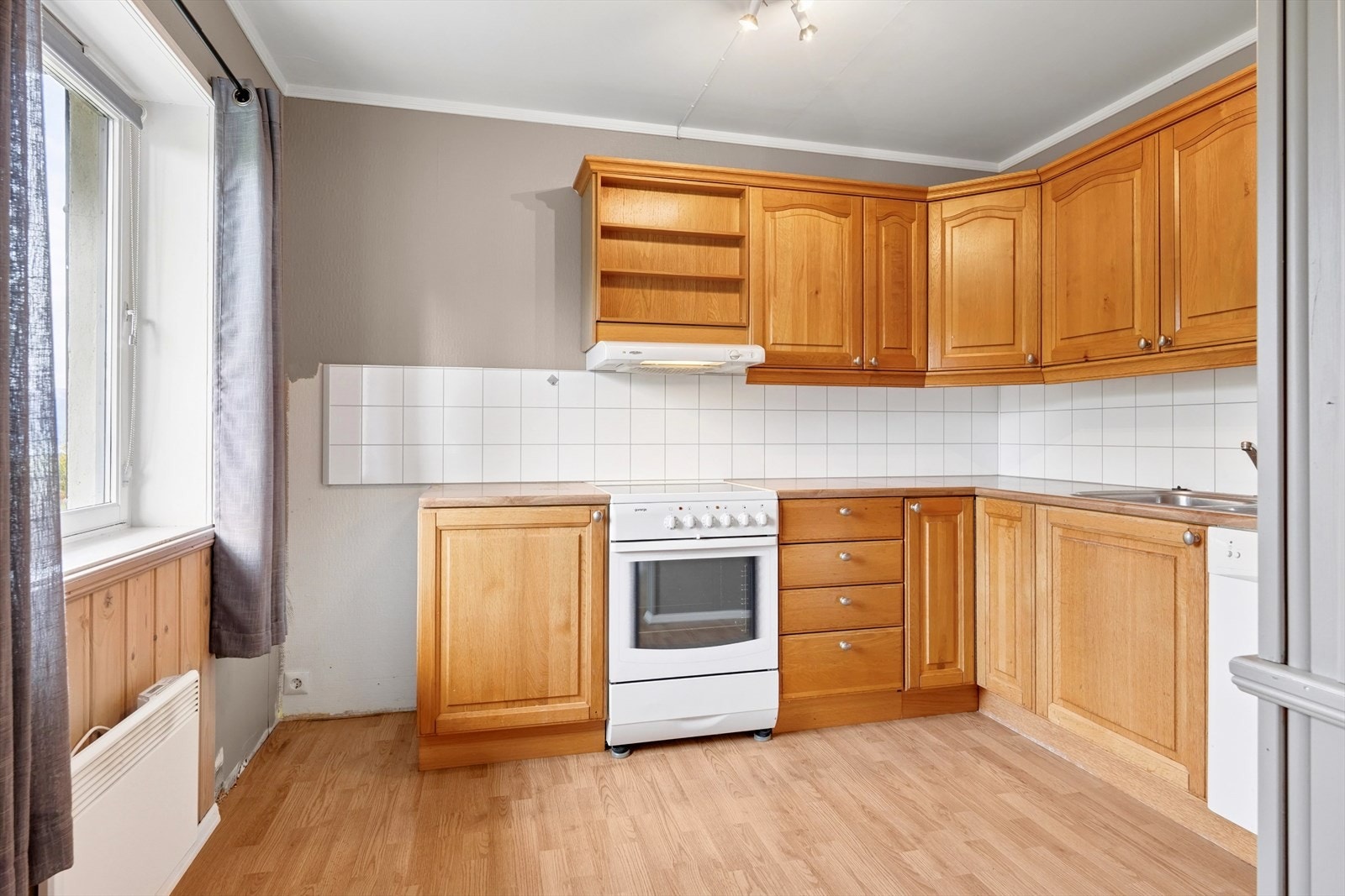 Kjøkkeninnredningen har profilerte fronter med benkeplate og nedfelt vask. Galleribilde