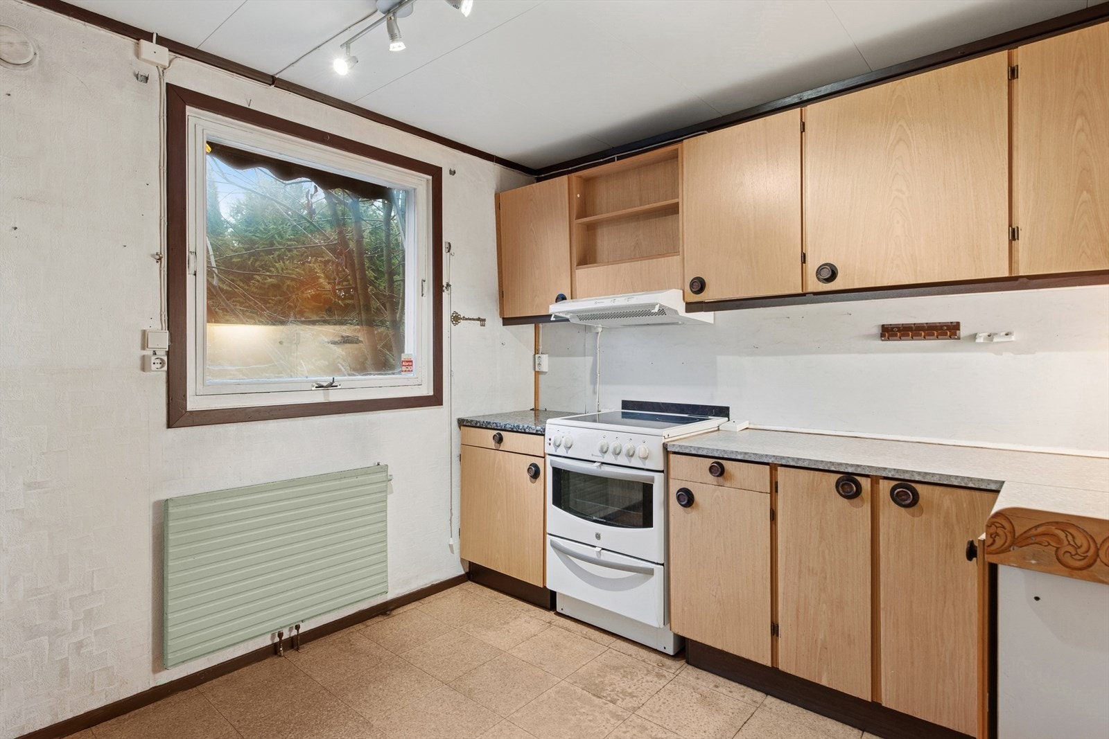 Kjøkken med innredning i tre med glatte fronter og laminert benkeplate. Galleribilde