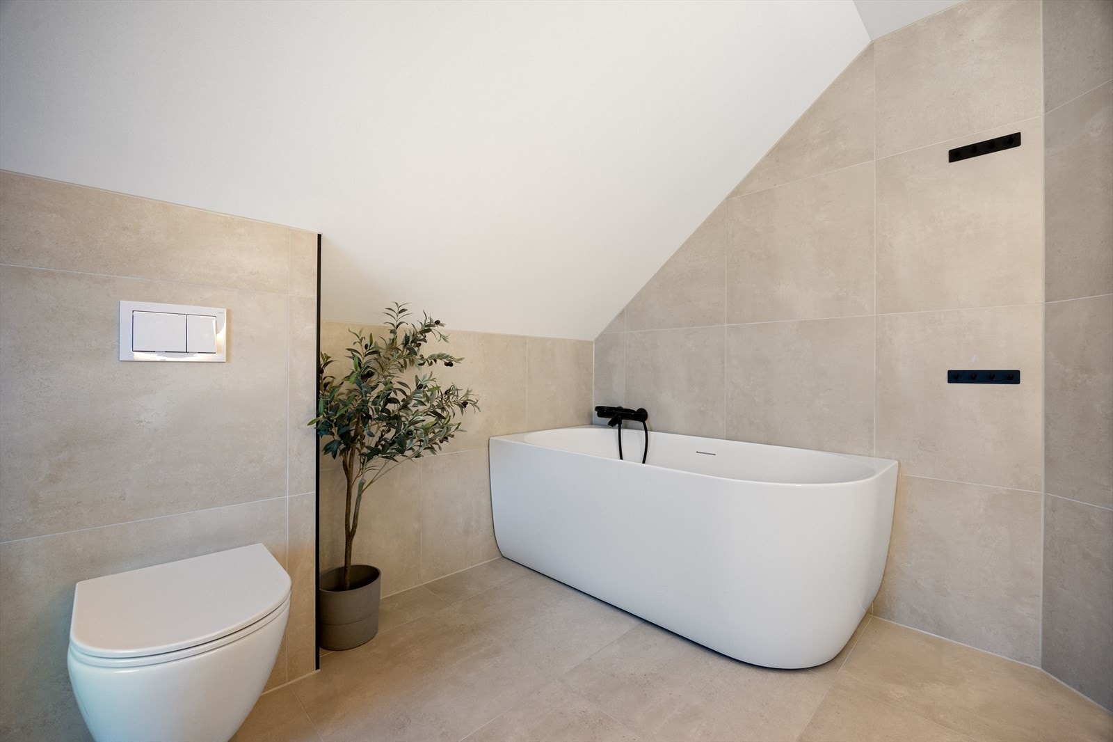 Her får du et helfliset rom med varmekabler, innfelt belysning, vegghengt toalett, dusjkabinett, badekar og moderne baderomsinnredning. Galleribilde