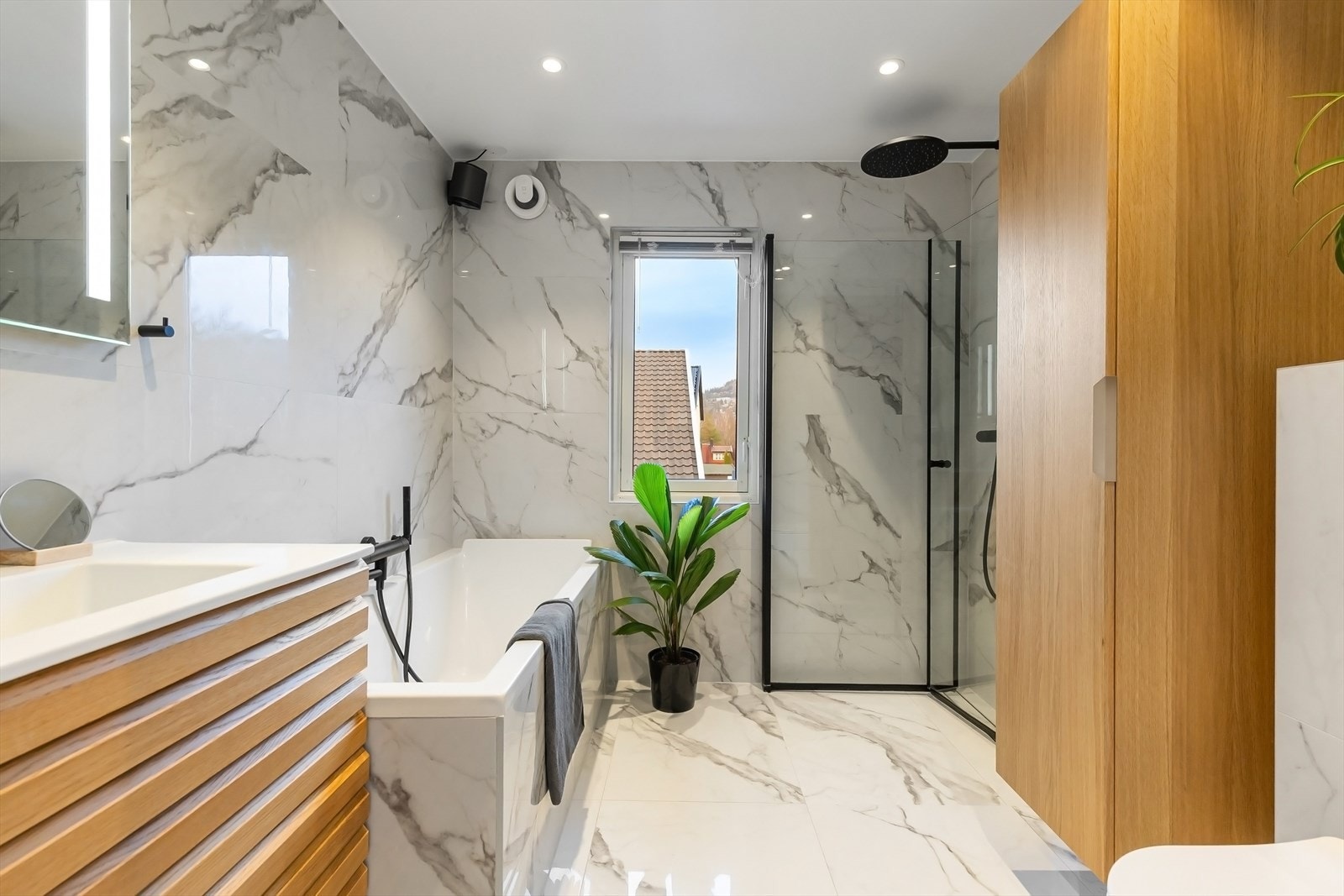 Moderne bad fra 2023 med speil med belysning over servant og varmekabler - Vindu gir en ekstra luftig følelse, samt ekstra god ventilasjon Galleribilde