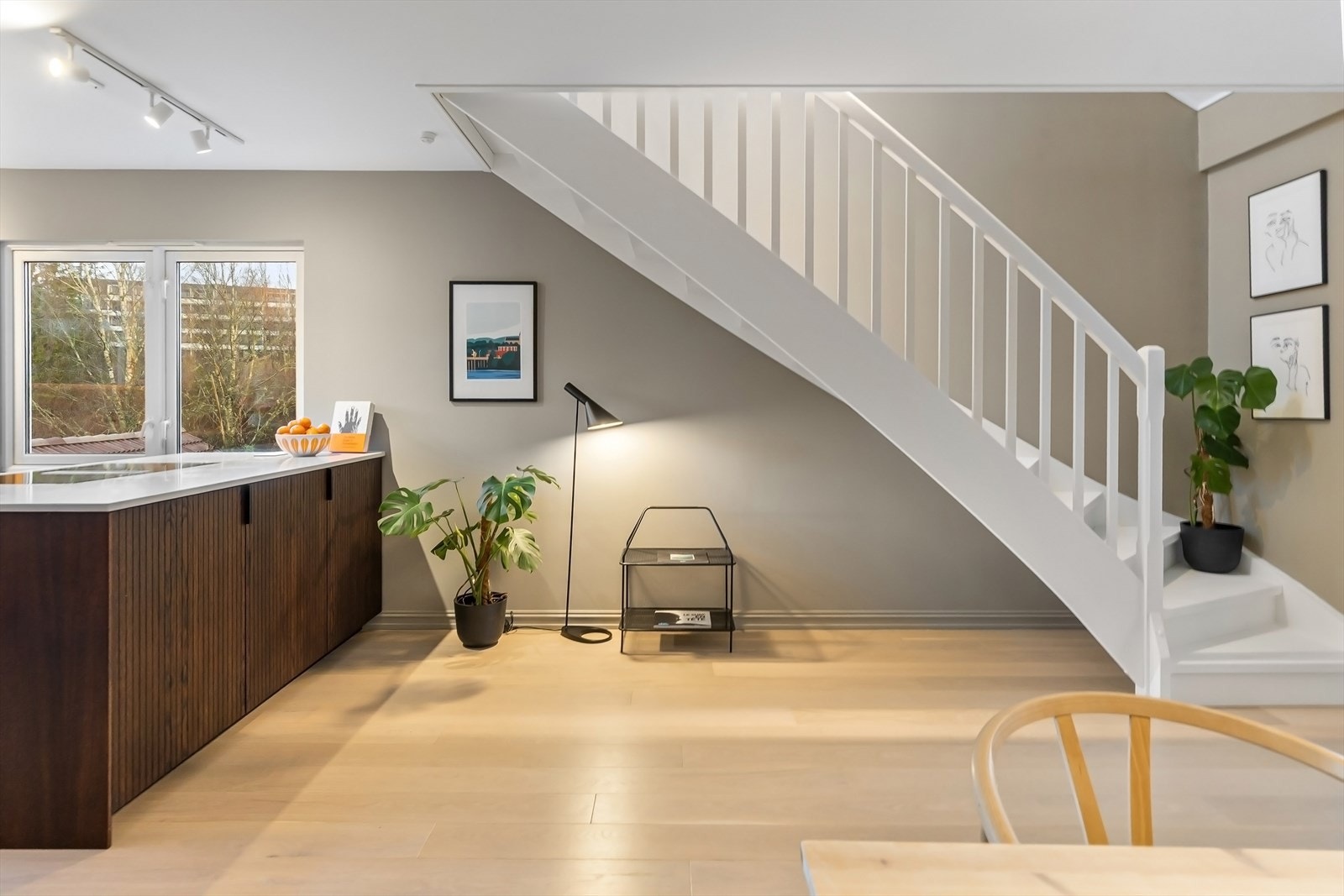 Åpen løsning mellom stue og kjøkken med kjøkkenøy som skaper et naturlig skille Galleribilde