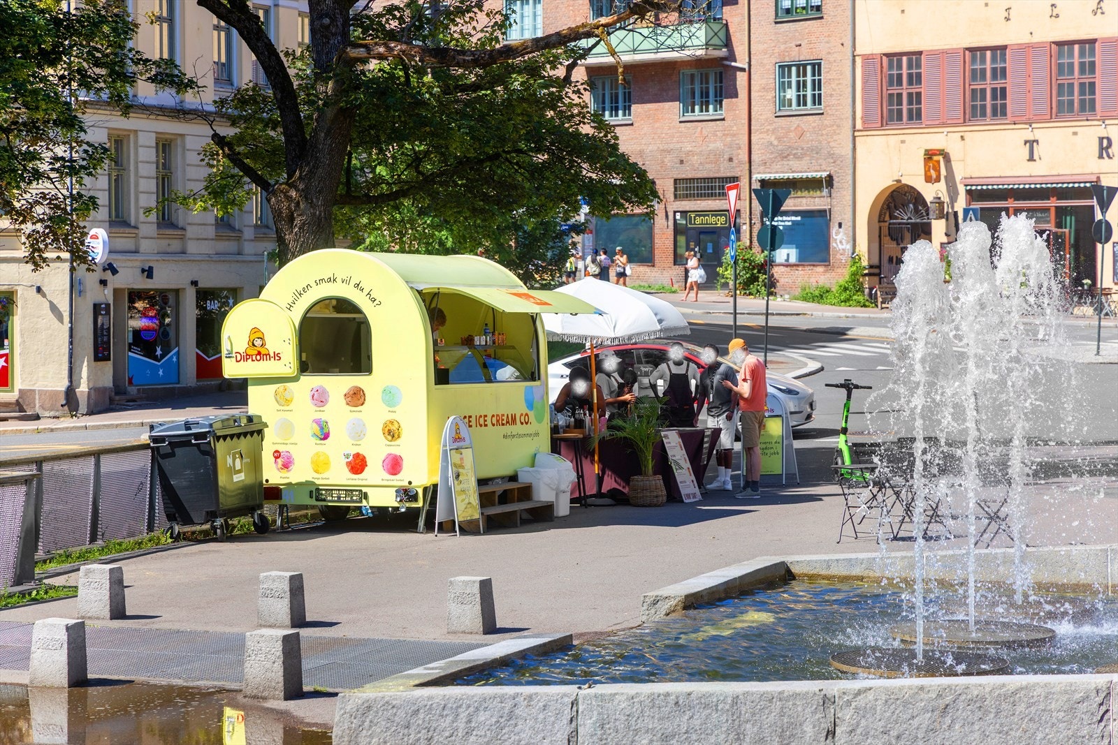Utsyn mot en livlig gate med iskremsalg og fontene gir en urban opplevelse. Galleribilde
