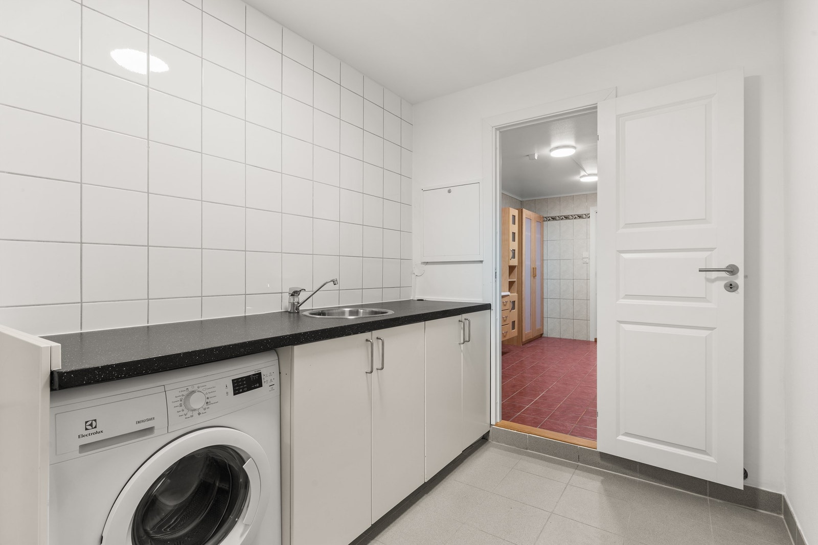 Videre er det et praktisk vaskerom i boligen med opplegg for vaskemaskin. Galleribilde