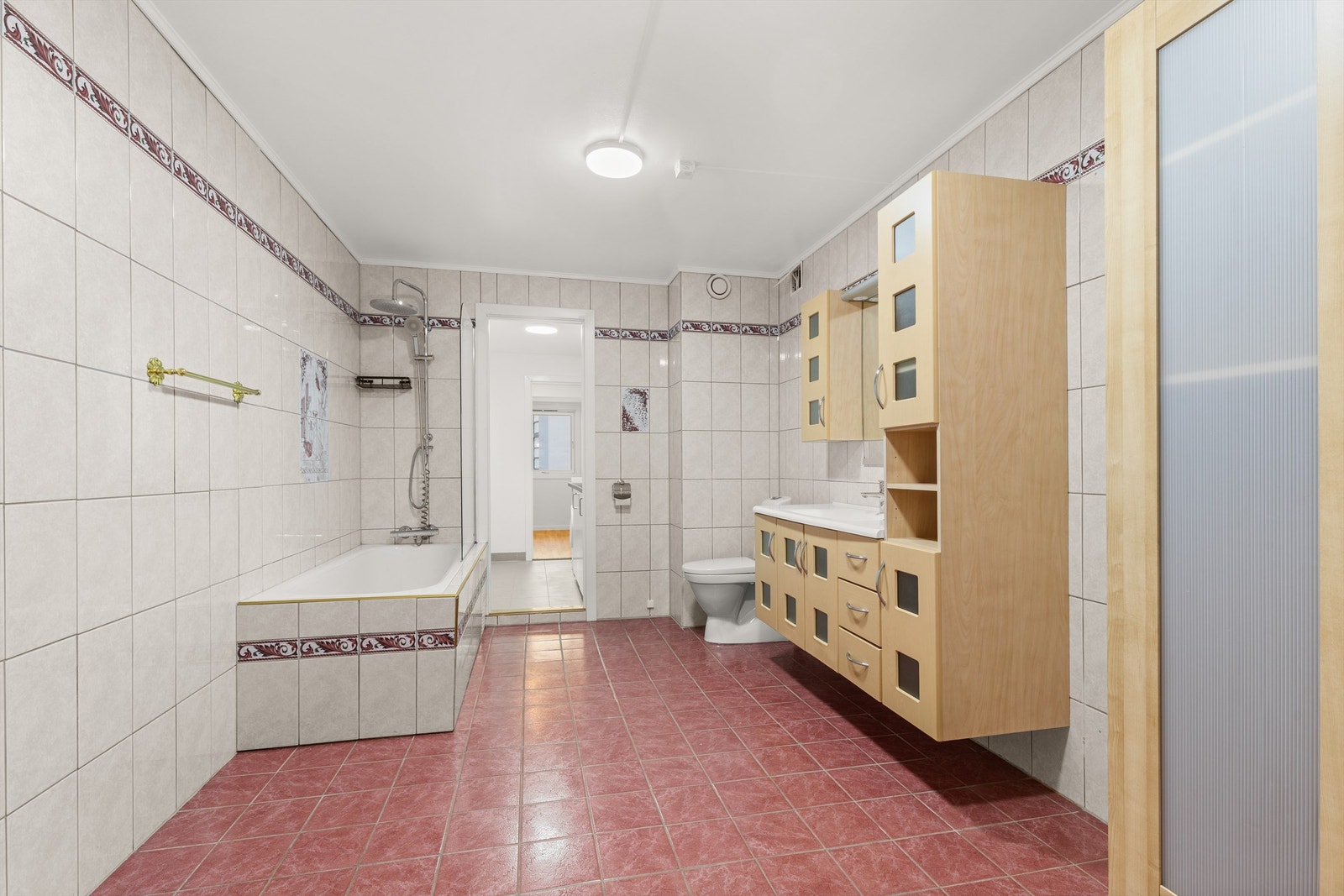 Rommet er innredet med klosett, servant med innredning, speil m/lys og innmurt badekar. Galleribilde