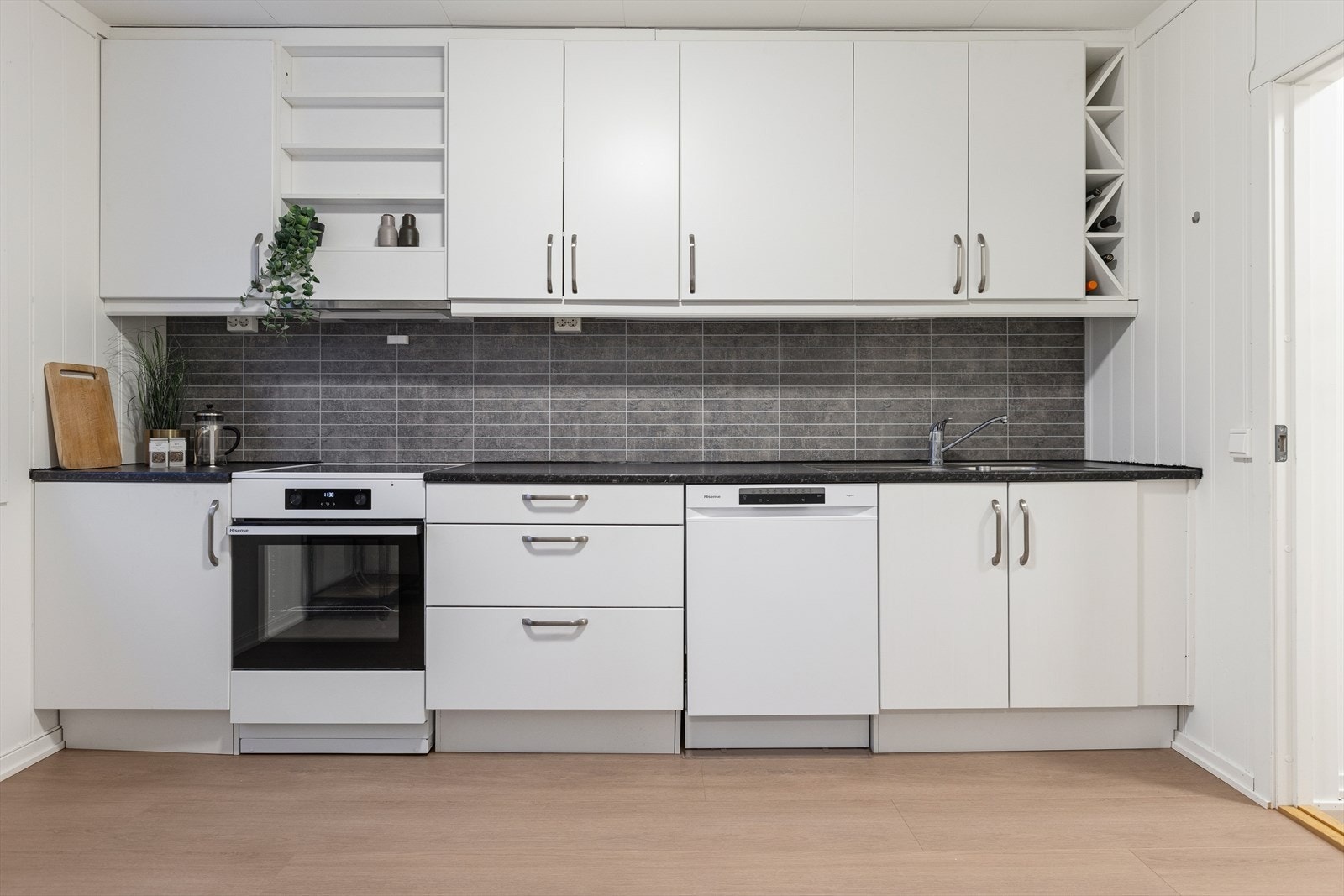 Kjøkkenet har modulbasert innredning med glatte fronter og en benkeplate i laminat. Galleribilde