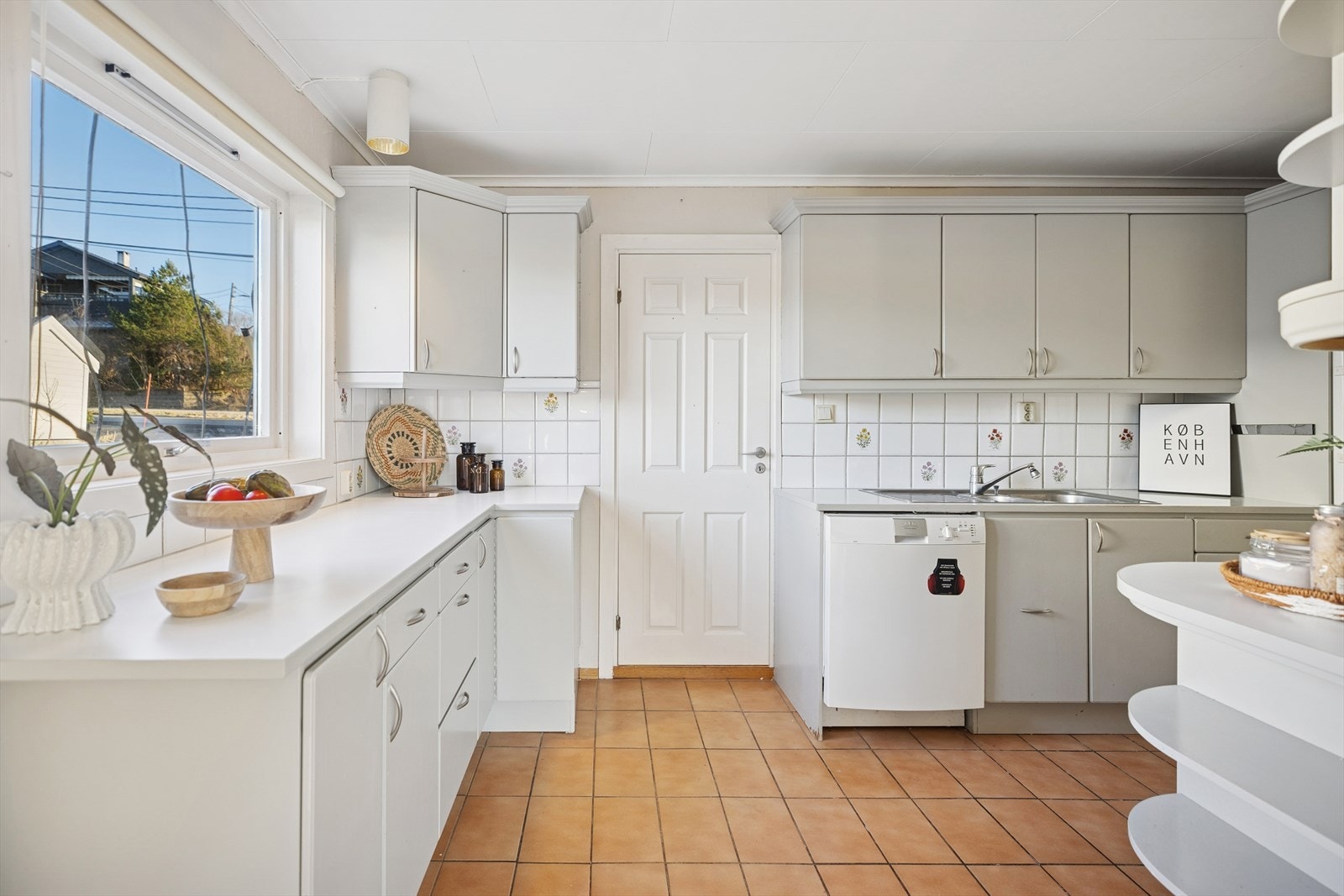 Kjøkkenet har en innholdsrik malt innredning med glatte fronter og laminat benkeplate. Galleribilde