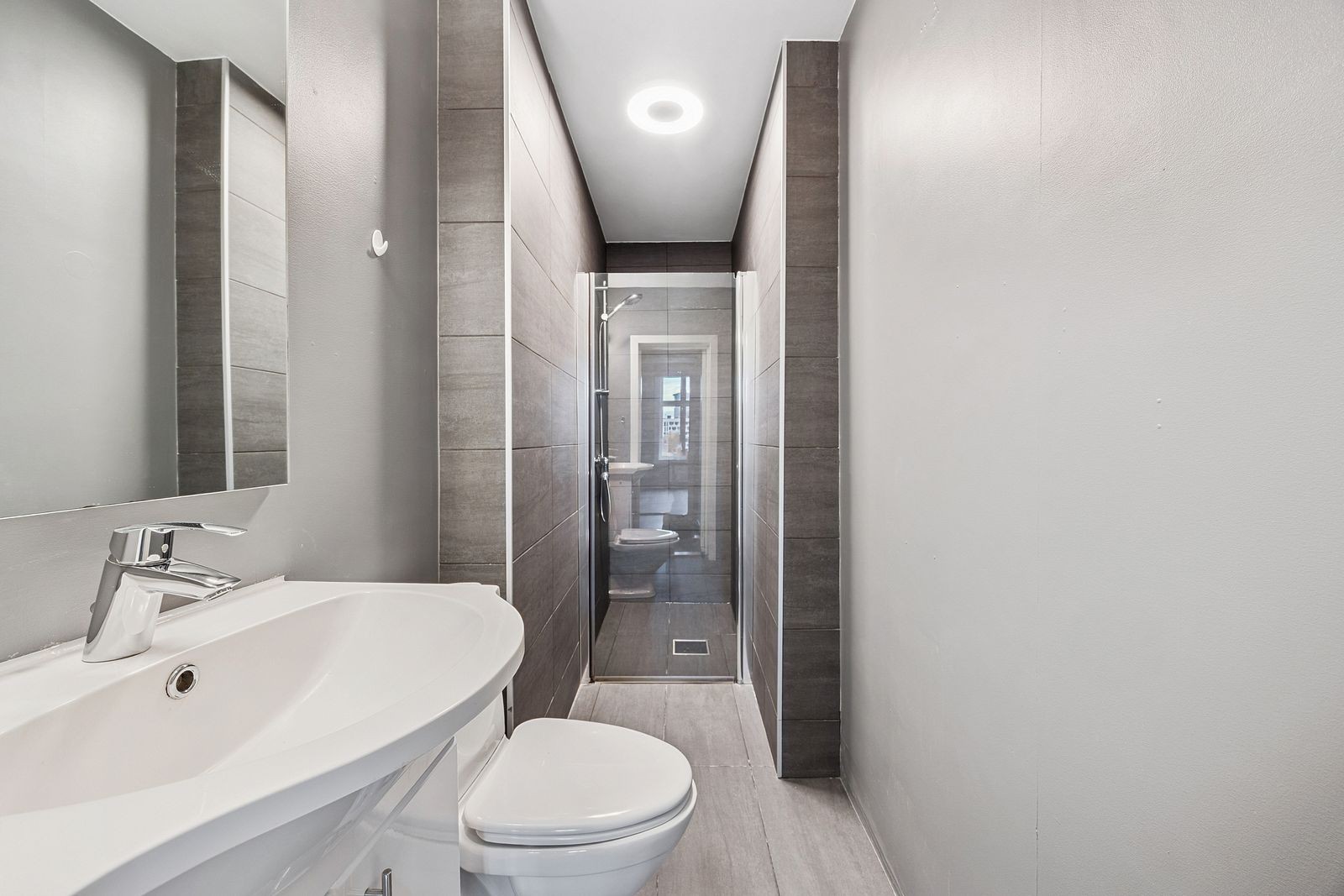 Flislagt bad med oppbevaring under servant. Galleribilde