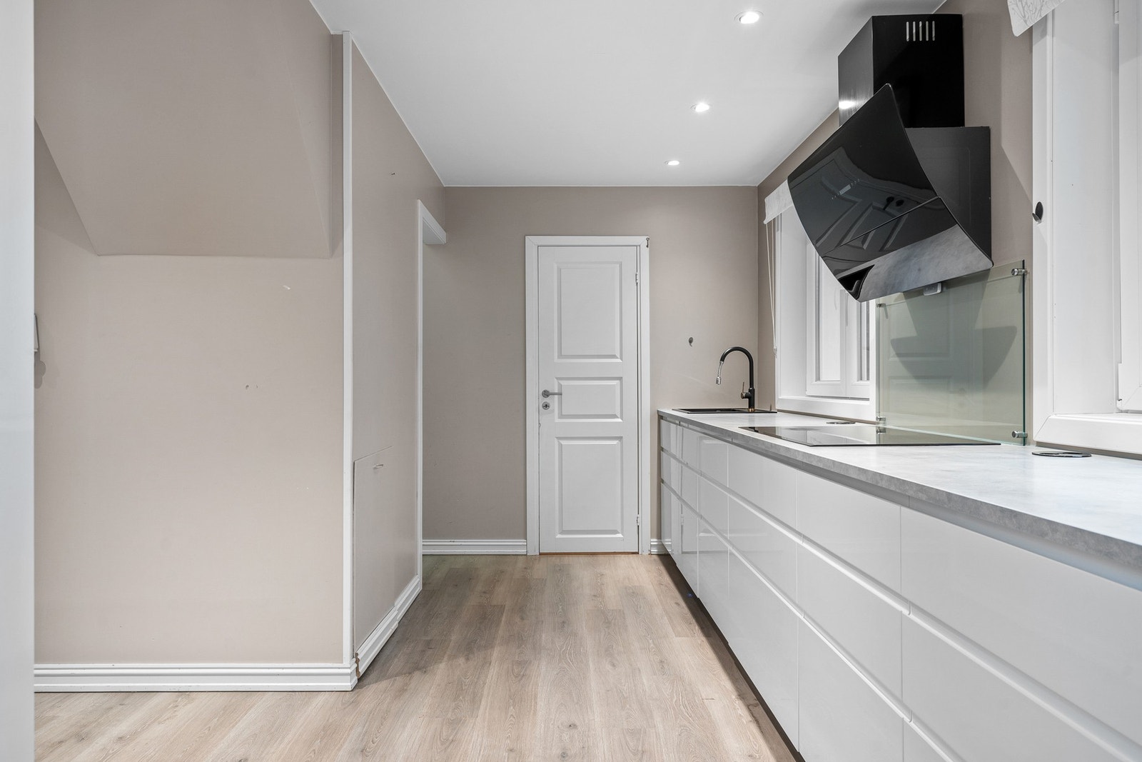 Dør går inn til en praktisk bod med ytterdør ut. Nedgang til kjeller til venstre i denne delen av rommnet Galleribilde