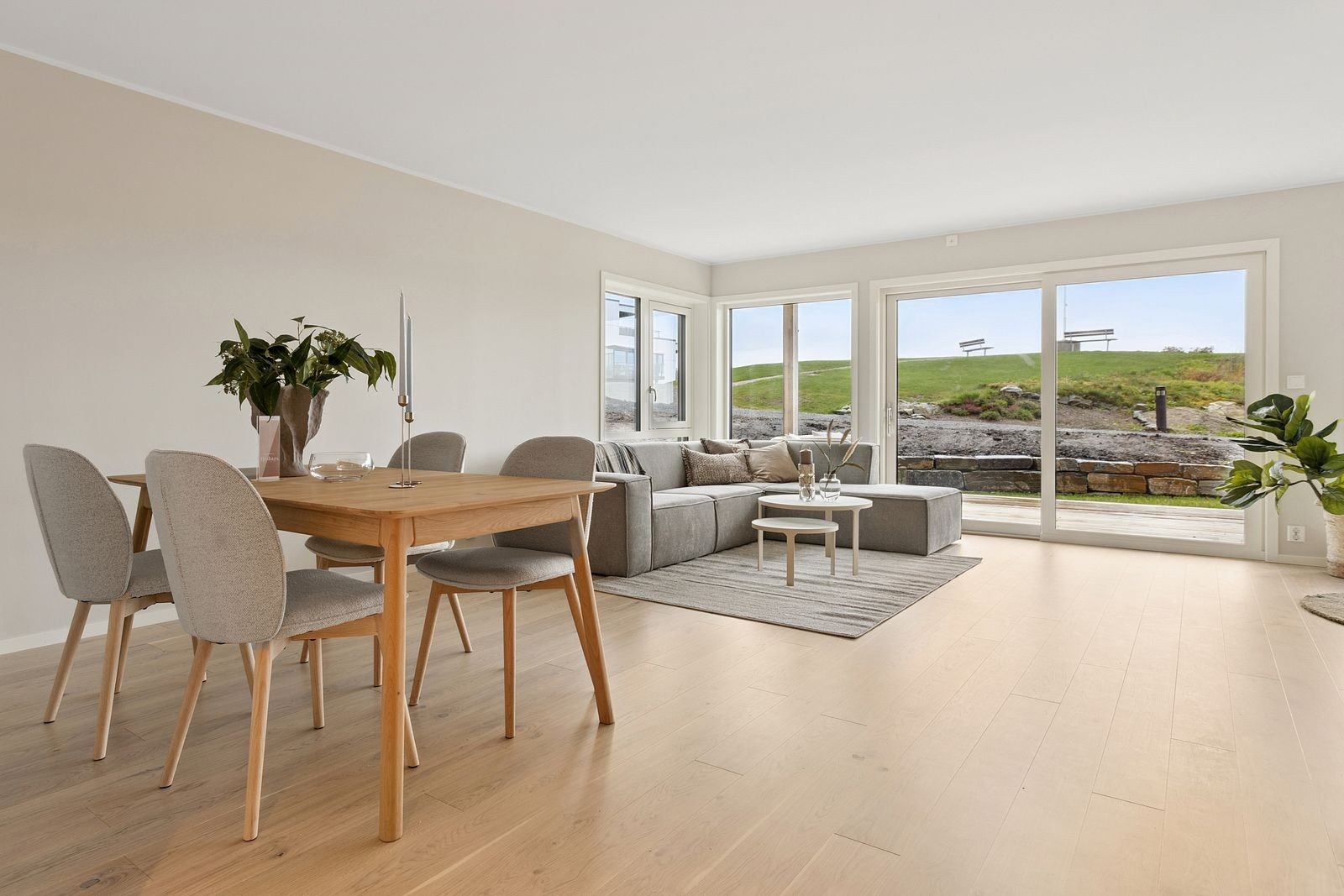 Stor L-formet stue med flere soner til sittegrupper. Galleribilde