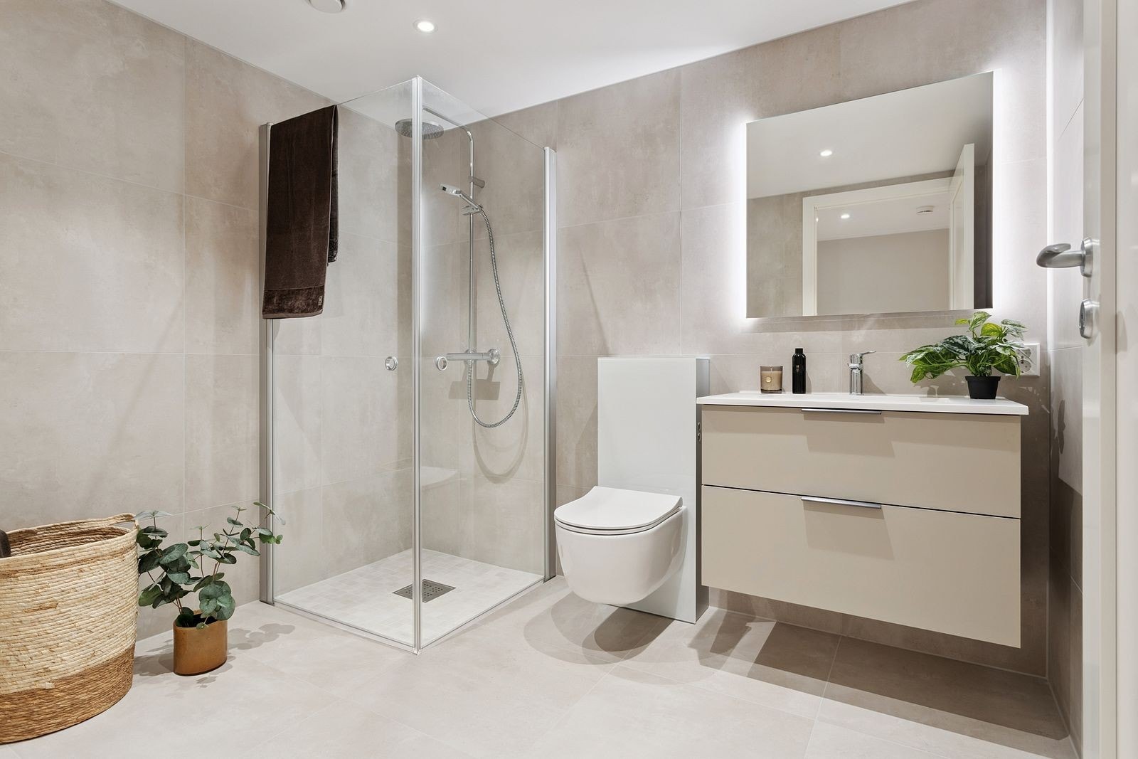 Lekkert bad med baderomsmøbel fra HTH, vegghengt toalett og dusjhjørne med glassdører. Opplegg til vaskemaskin. Galleribilde