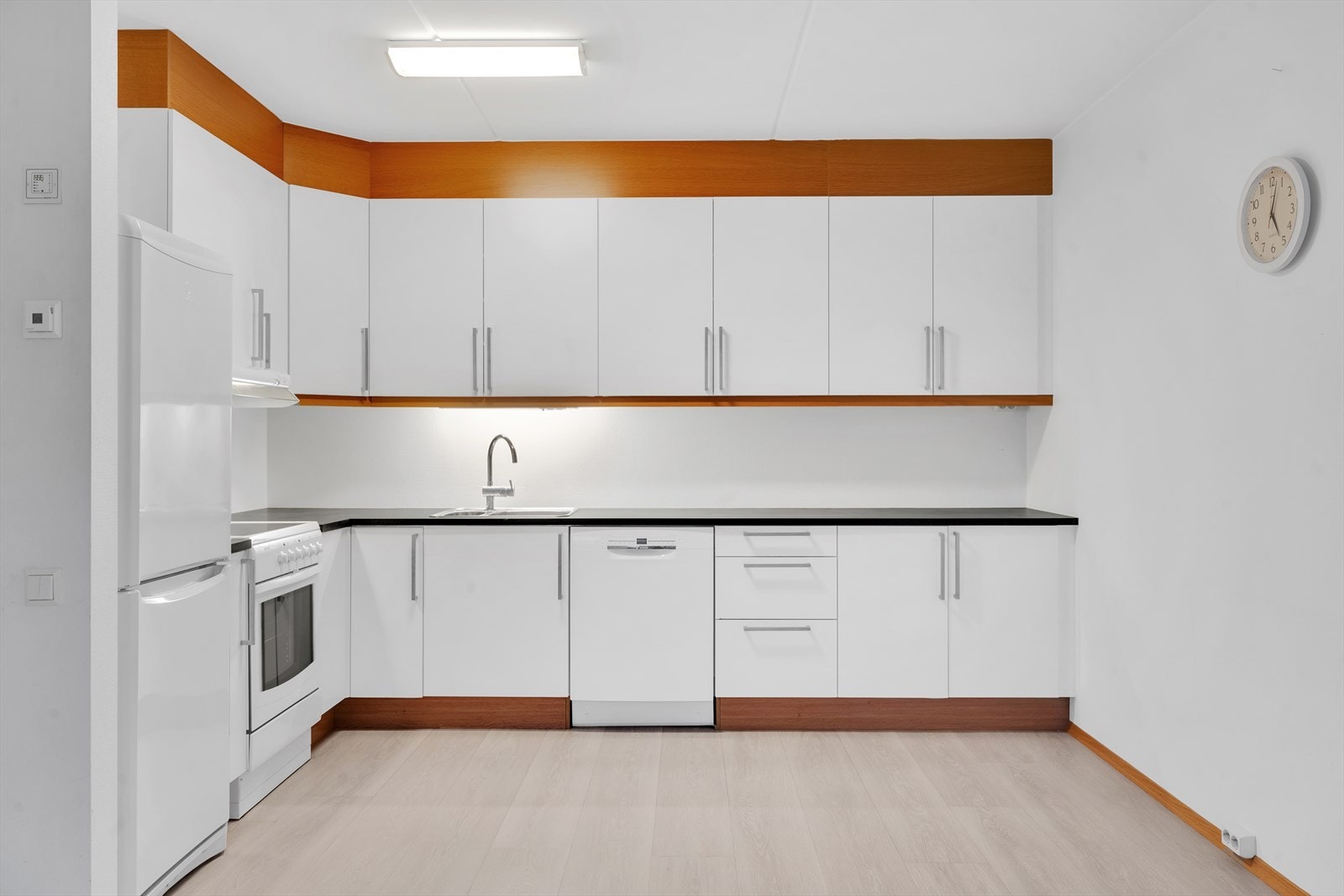 Kjøkken gjennomført i hvite overflater med mye skap- og benkeplass. Galleribilde