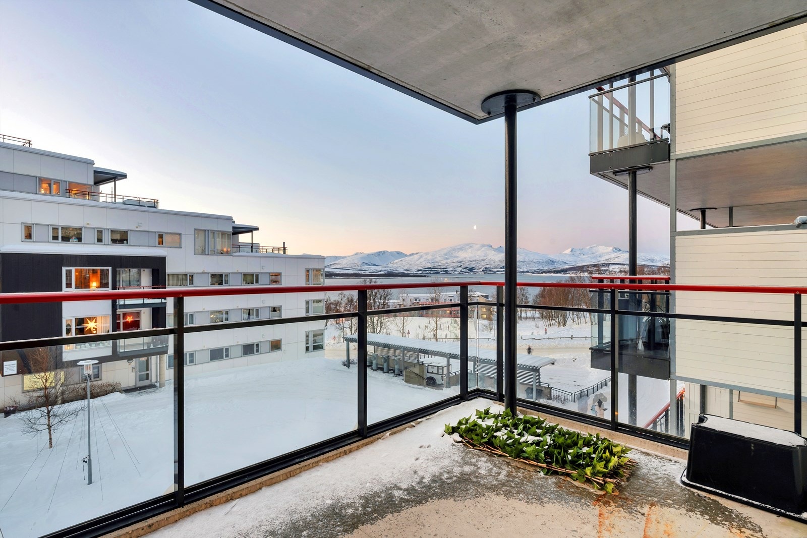 Sørvestvendt takoverbygd balkong med flott utsikt over nærområdet, samt sundet og Kvaløya i bakgrunnen. Galleribilde