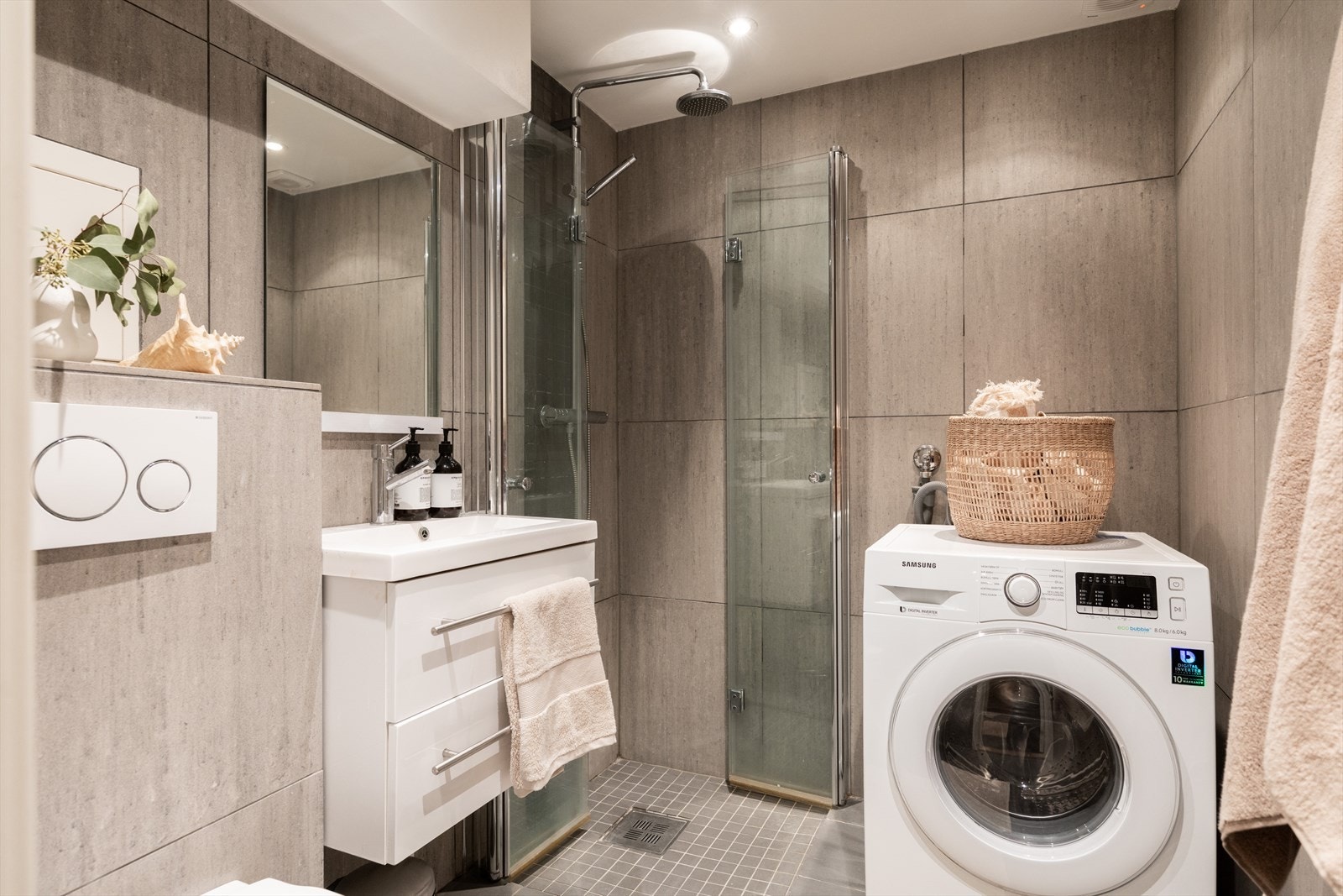 Pent bad fra 2018 med fliser på vegger og fliser med varmekabler på gulvet. Badet er innredet med nedfelt servant, overhengende speil og tilhørende belysning. Galleribilde