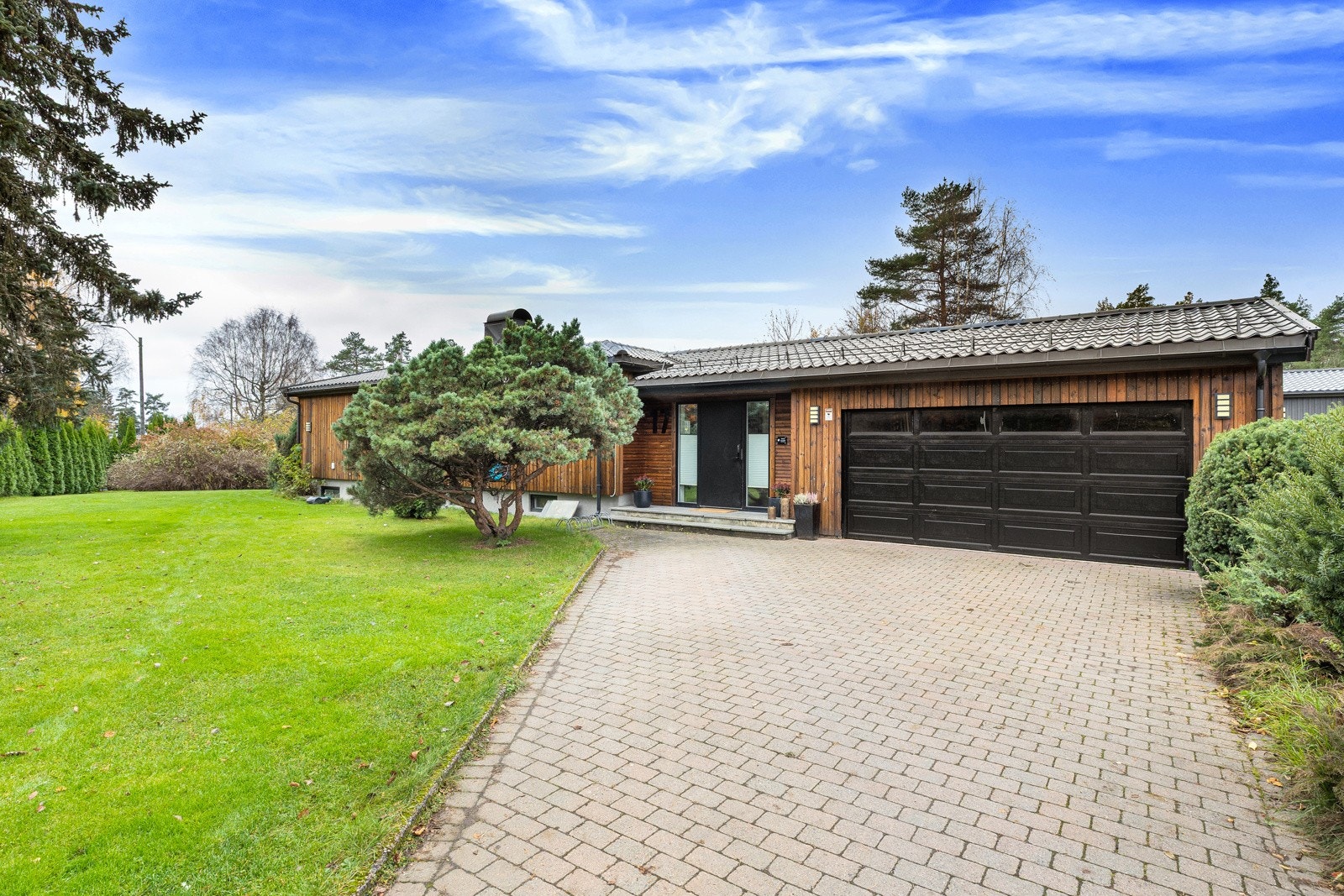 Stor og flott gårdsplass med beleggningstein. Her det det rikelig med parkeringsplass. Galleribilde
