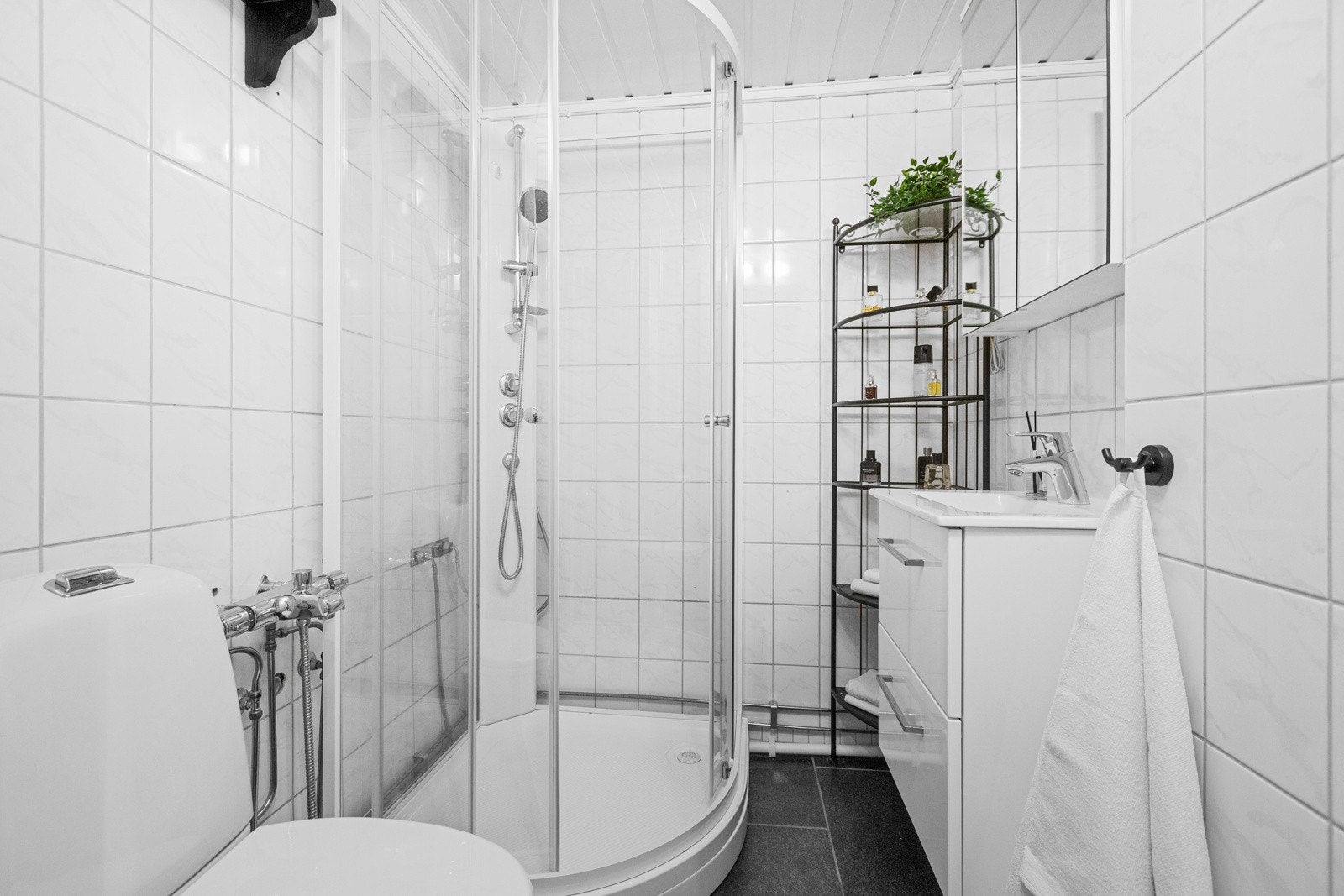 Badet har installert toalett, dusjkabinett og vask med underskap Galleribilde