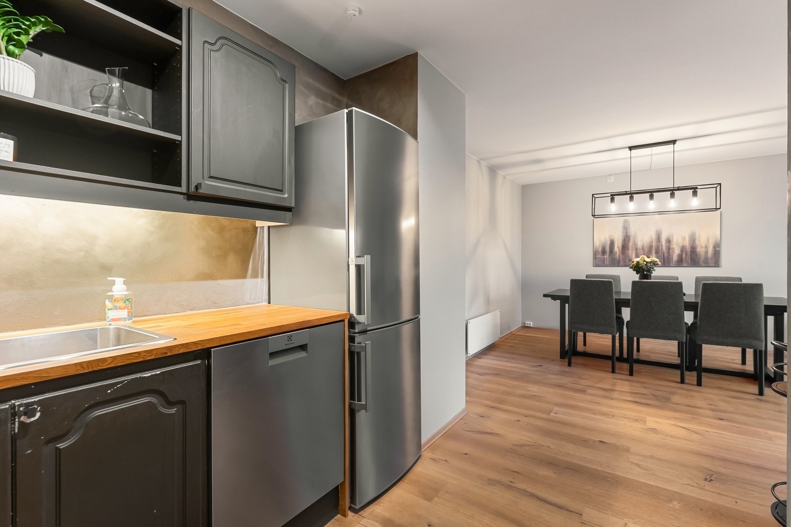 Kjøkkeninnredningen har profilerte fronter og hvitevarer inkluderer frittstående komfyr med induksjonstopp og ny oppvaskmaskin fra 2023 Galleribilde