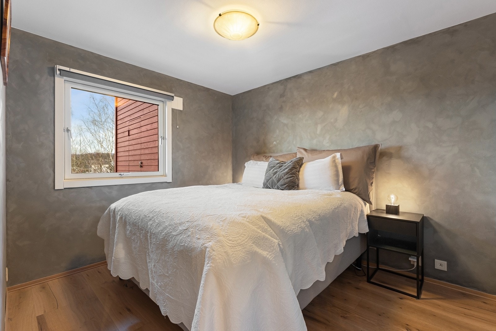 Boligen har et romslig soverom med plass til dobbeltseng med nattbord på hver side Galleribilde